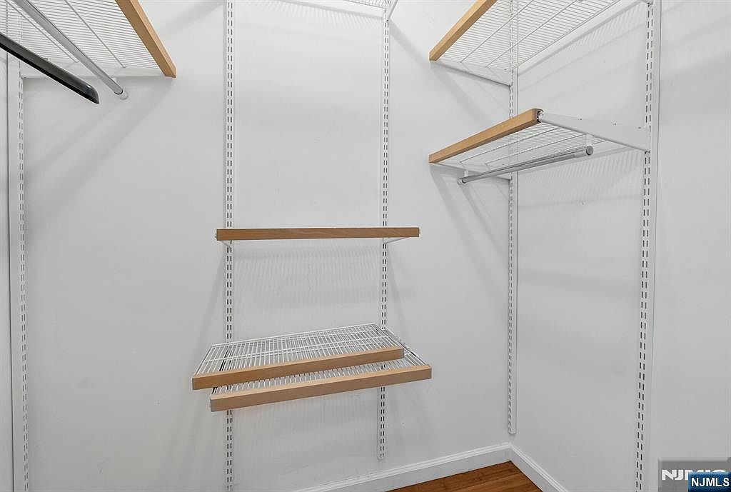 Primary suite walk-in closet with built-in shelving