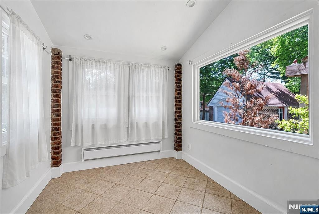 Primary bedroom with bamboo floors, cathedral ceilings, and large picture window