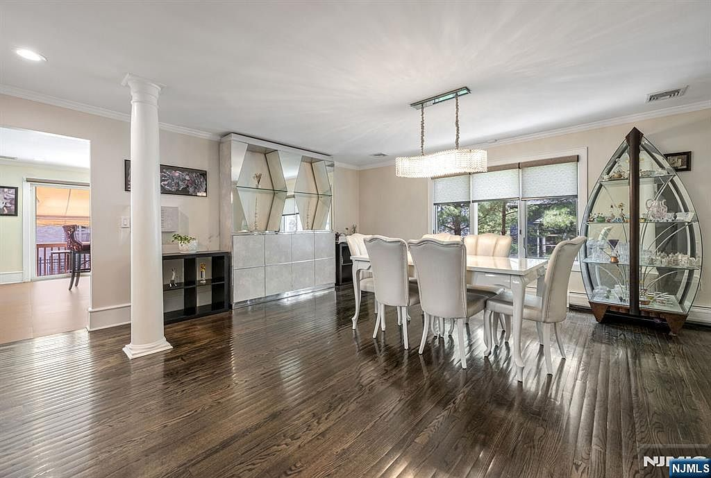 Formal dining room with dark hardwood floors and crown molding