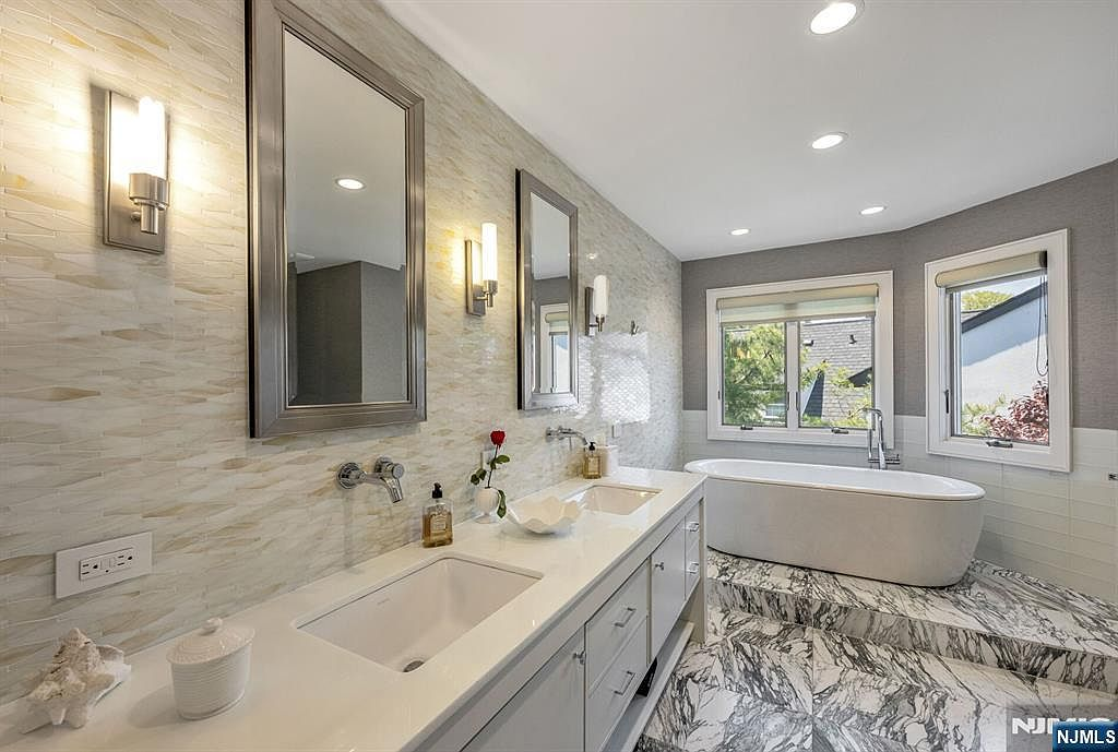 Primary marble spa bath with freestanding soaking tub and double vanity