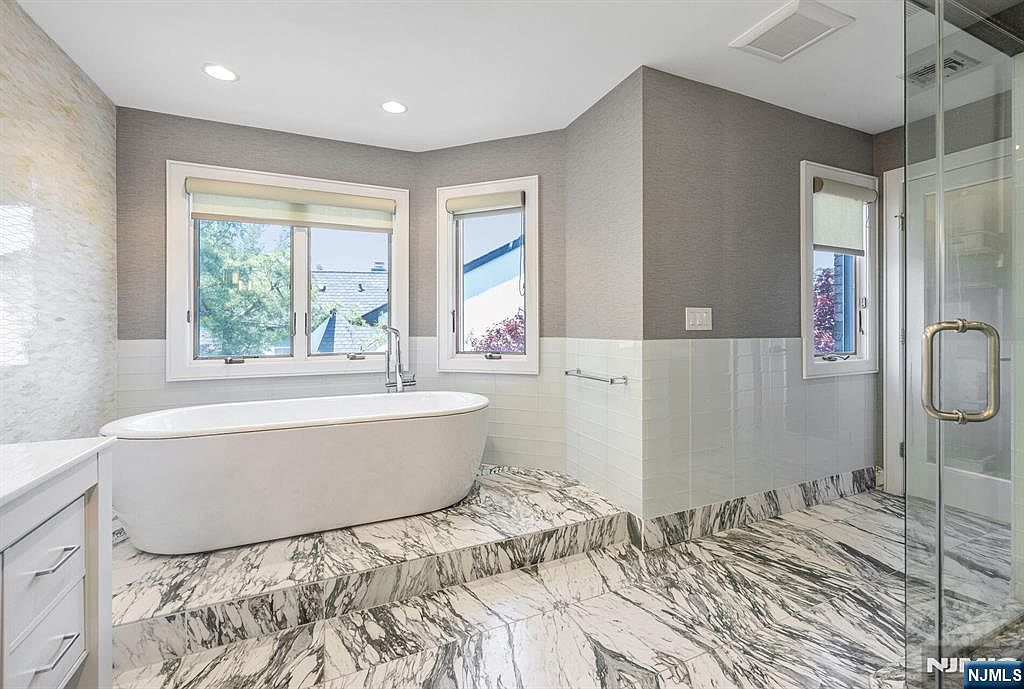 Marble bathroom with frameless glass shower and rainfall showerhead