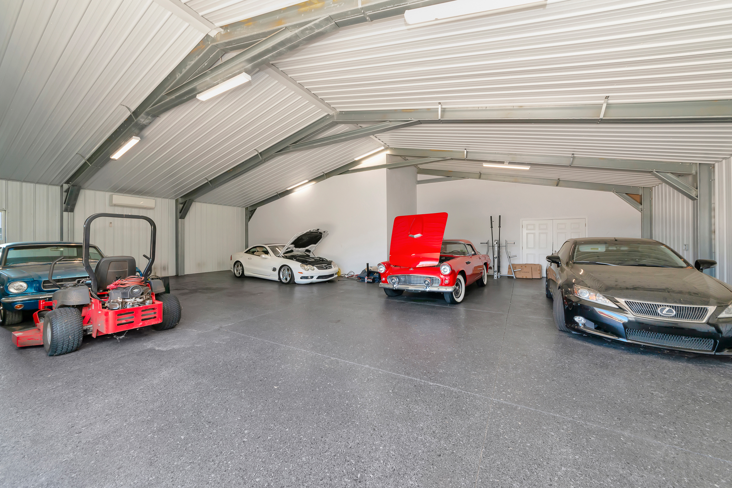 Multi-vehicle garage and storage interior of the second building with parked cars