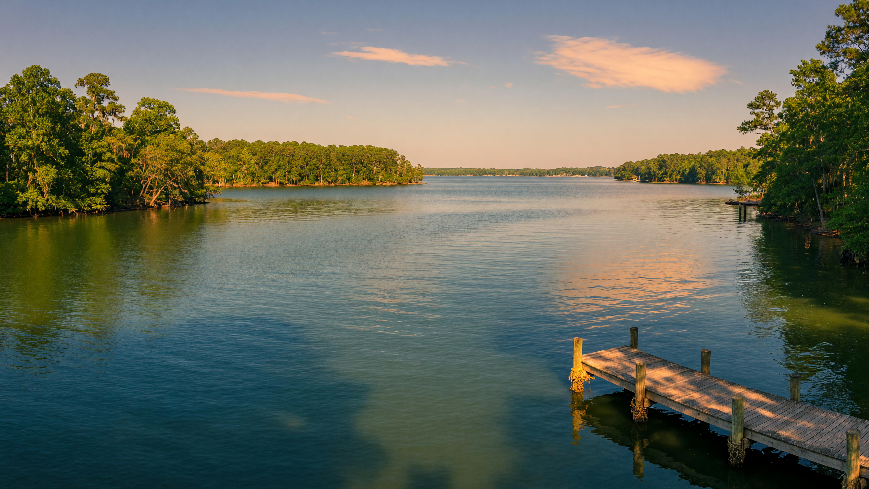 Aerial view of Lake Murray, South Carolina at golden hour with wooded shoreline and calm sunset water