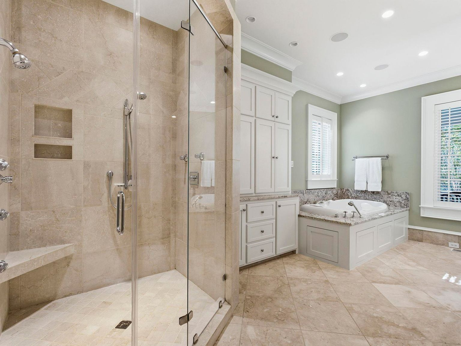 Master bathroom with soaking tub and travertine tile