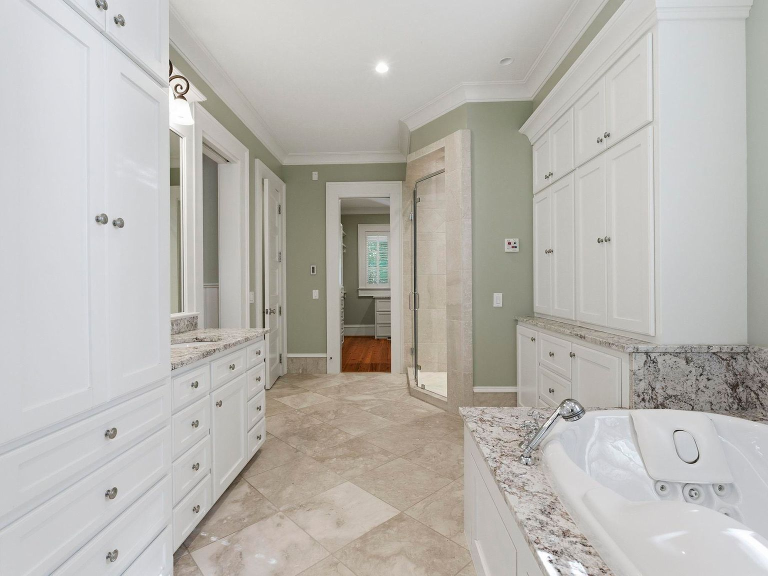 Master bathroom with custom white cabinetry and whirlpool tub