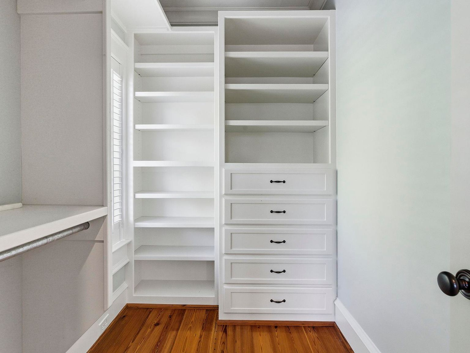 Walk-in closet with custom white cabinetry and oil-rubbed bronze hardware