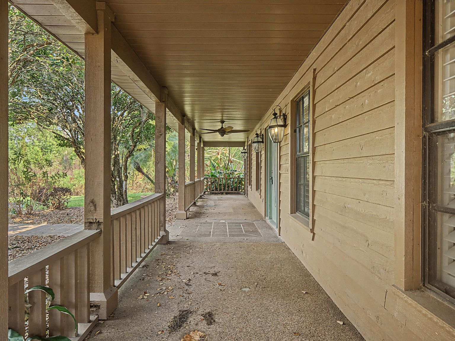 Long covered porch with wood beams and dappled sunlight