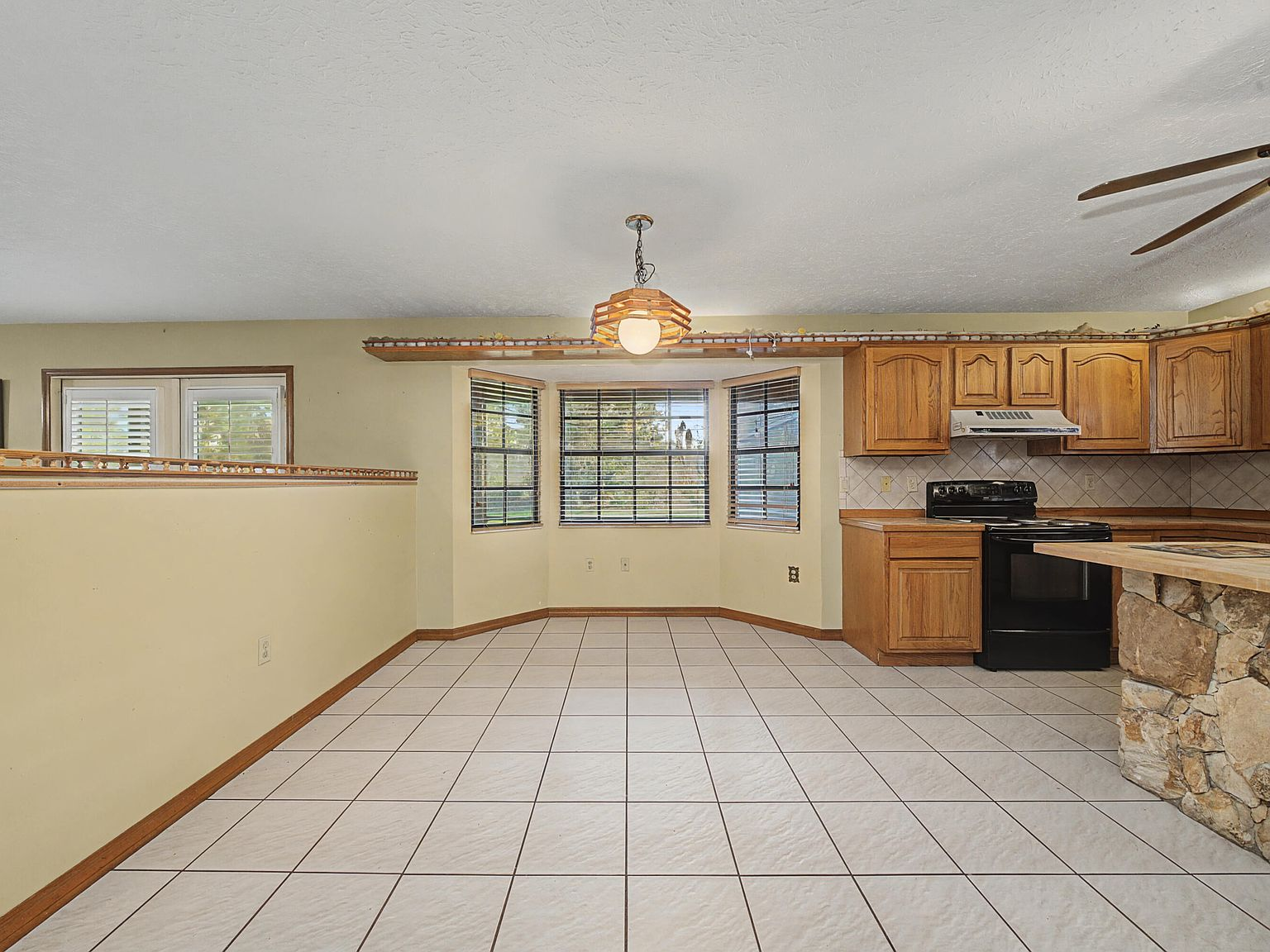 Eat-in kitchen dining nook with bay windows and tile flooring