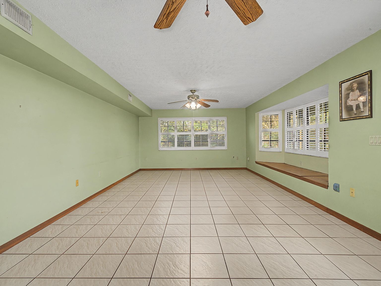 Flex space or second living area with tile flooring and window shutters