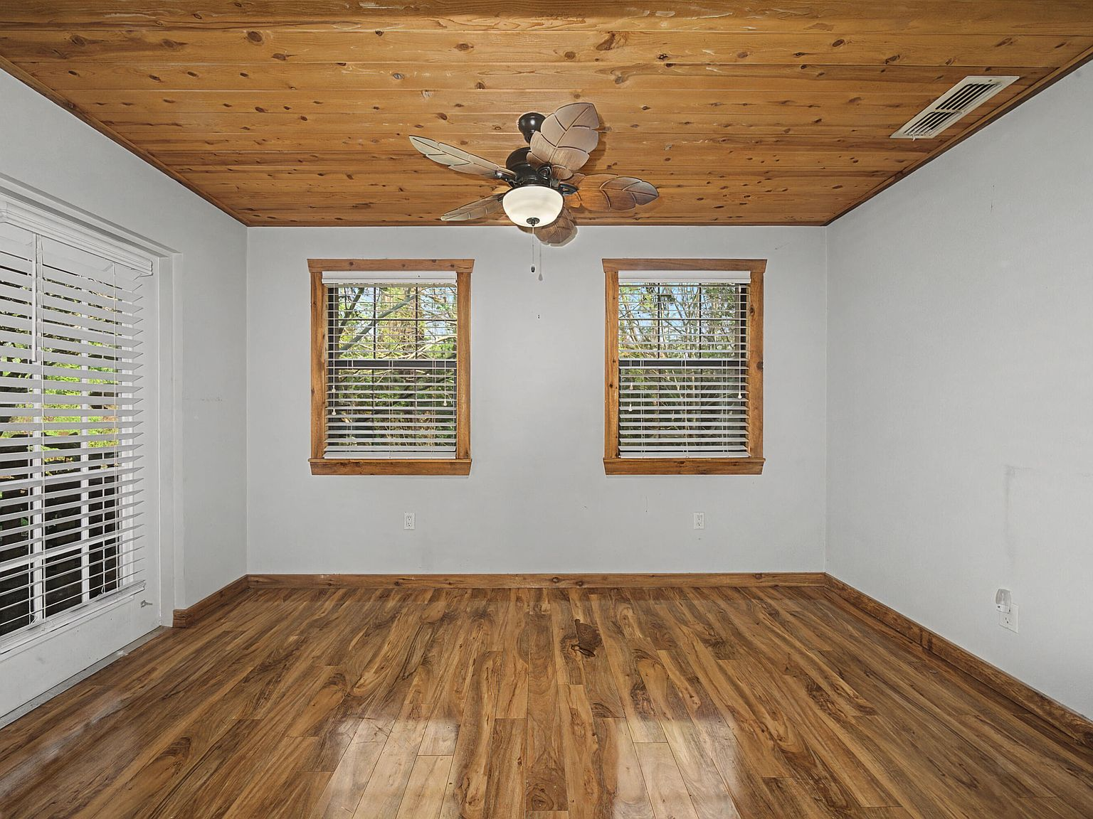 Upstairs bedroom with wood plank ceiling and sliding glass door