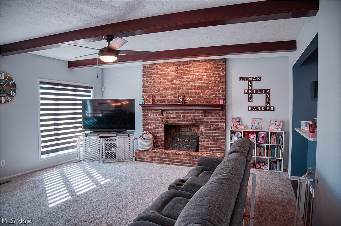 Living room with brick fireplace and exposed ceiling beams