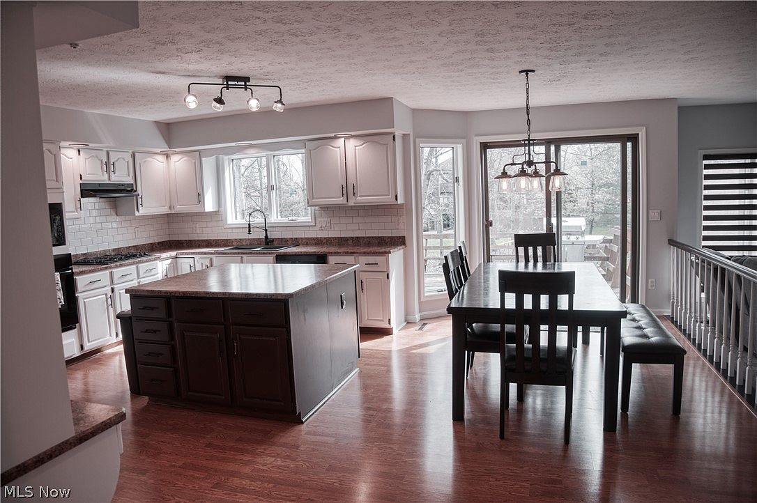 Open-concept kitchen and dining area with wood laminate flooring