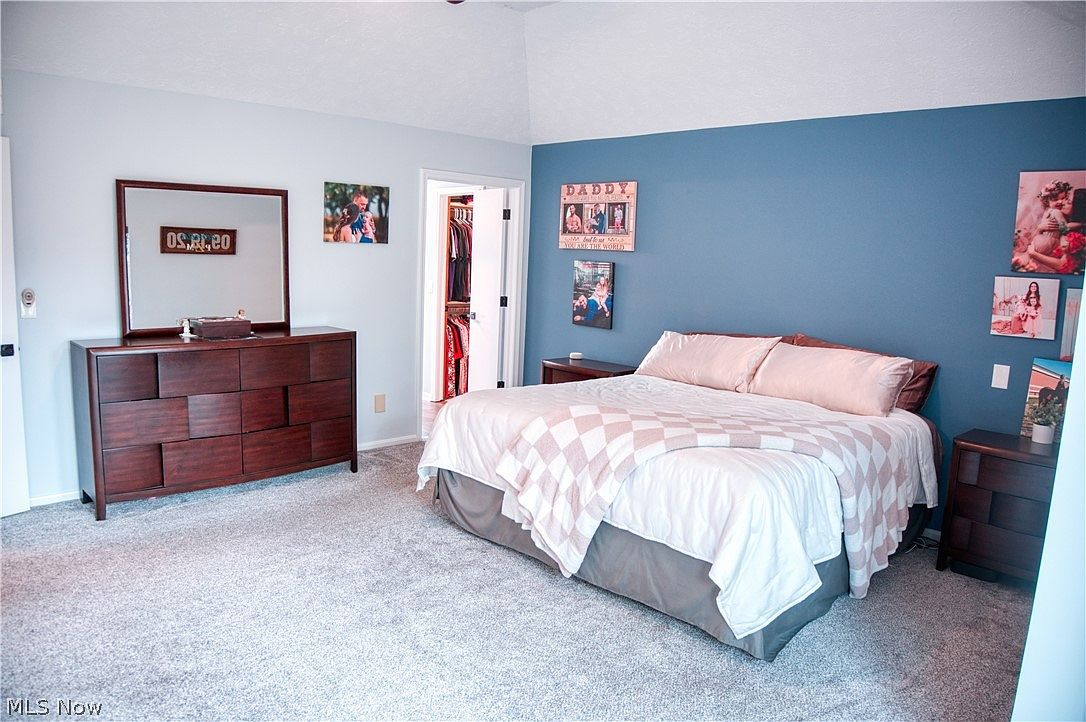Primary bedroom with vaulted ceilings and blue accent wall