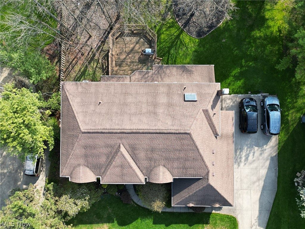Top-down aerial view of property showing roof, deck, and driveway