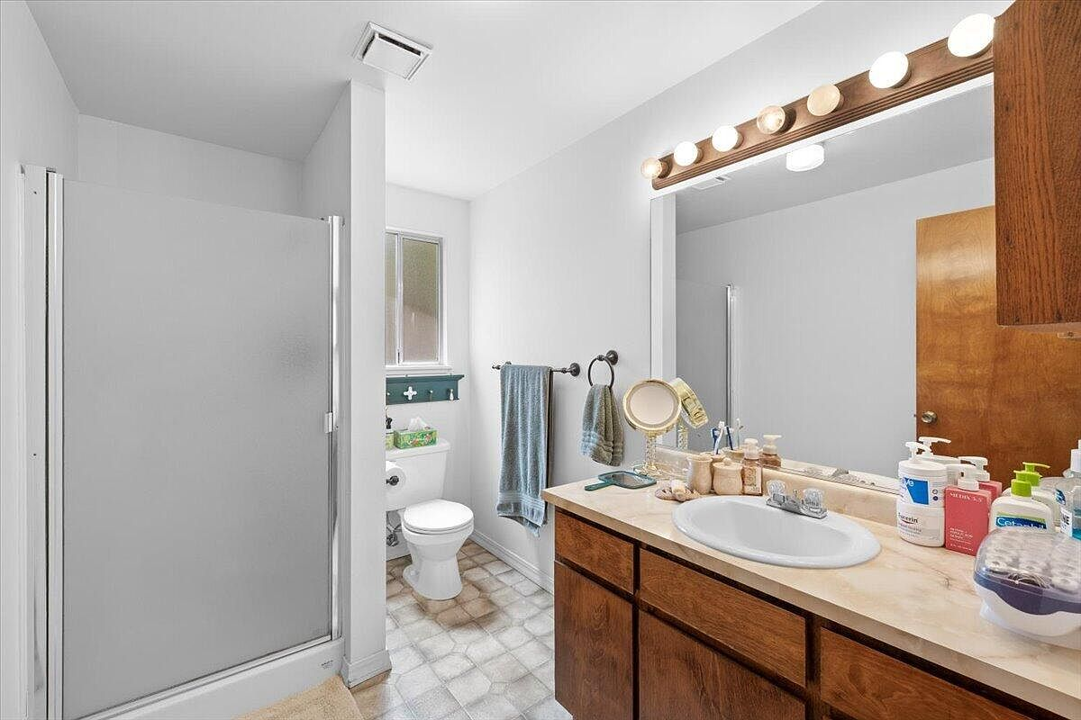 Main bathroom with vanity counter and frosted glass shower enclosure