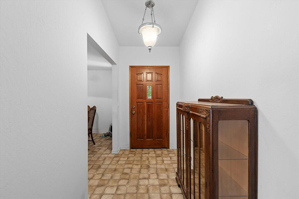 Entryway with wooden front door, glass insert, and tile flooring