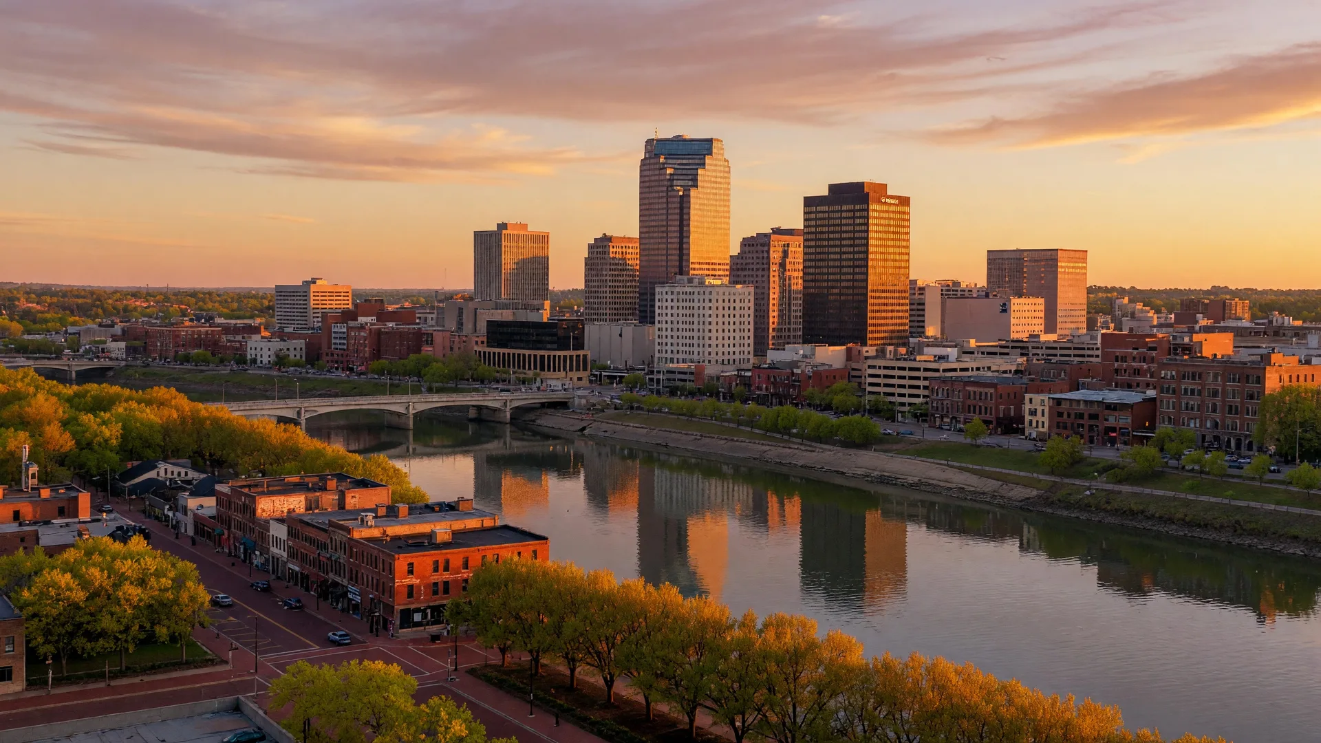Aerial view of downtown Dayton Ohio skyline at golden hour along the Great Miami River