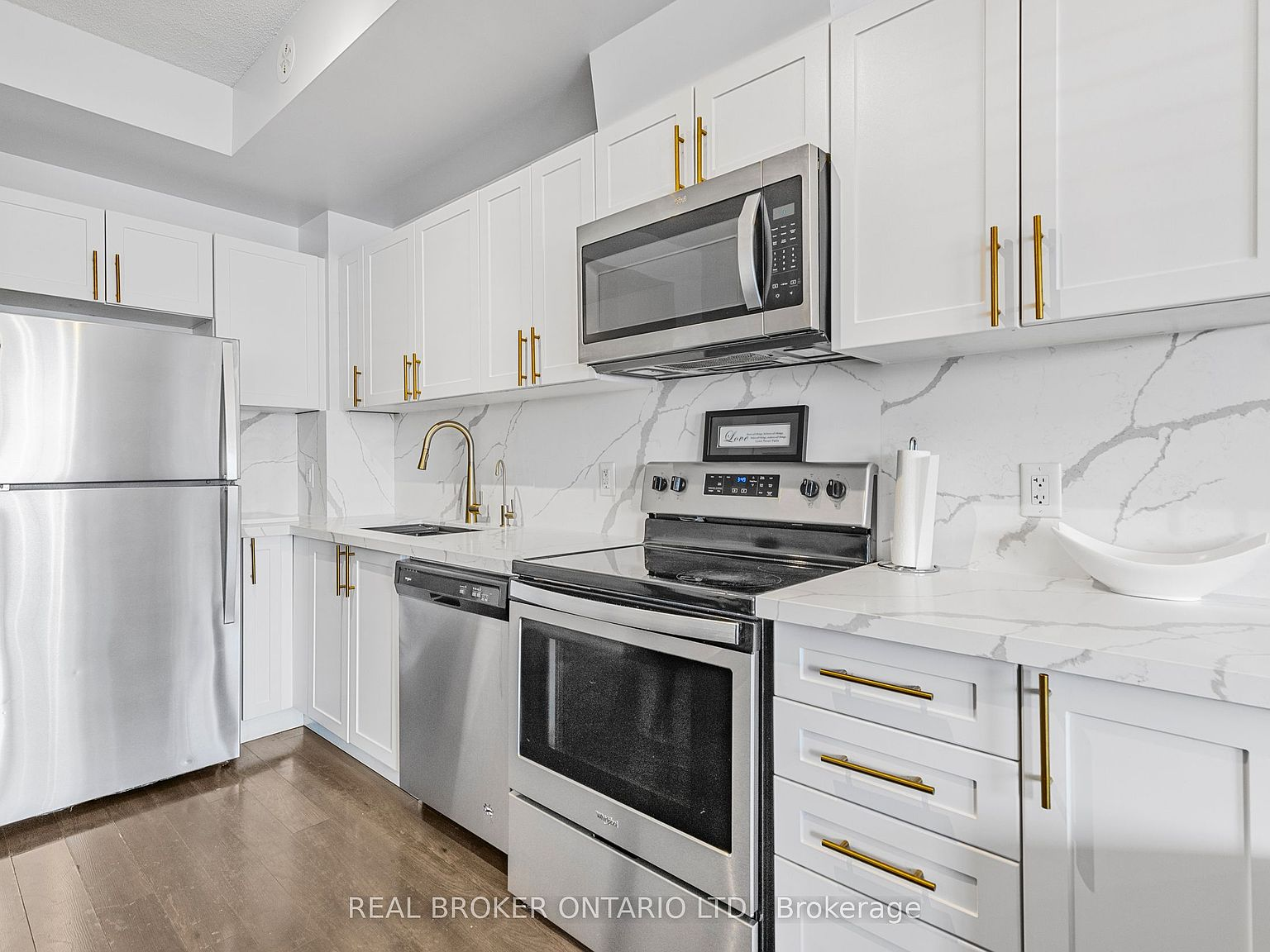 Modern white kitchen with quartz countertops and gold hardware