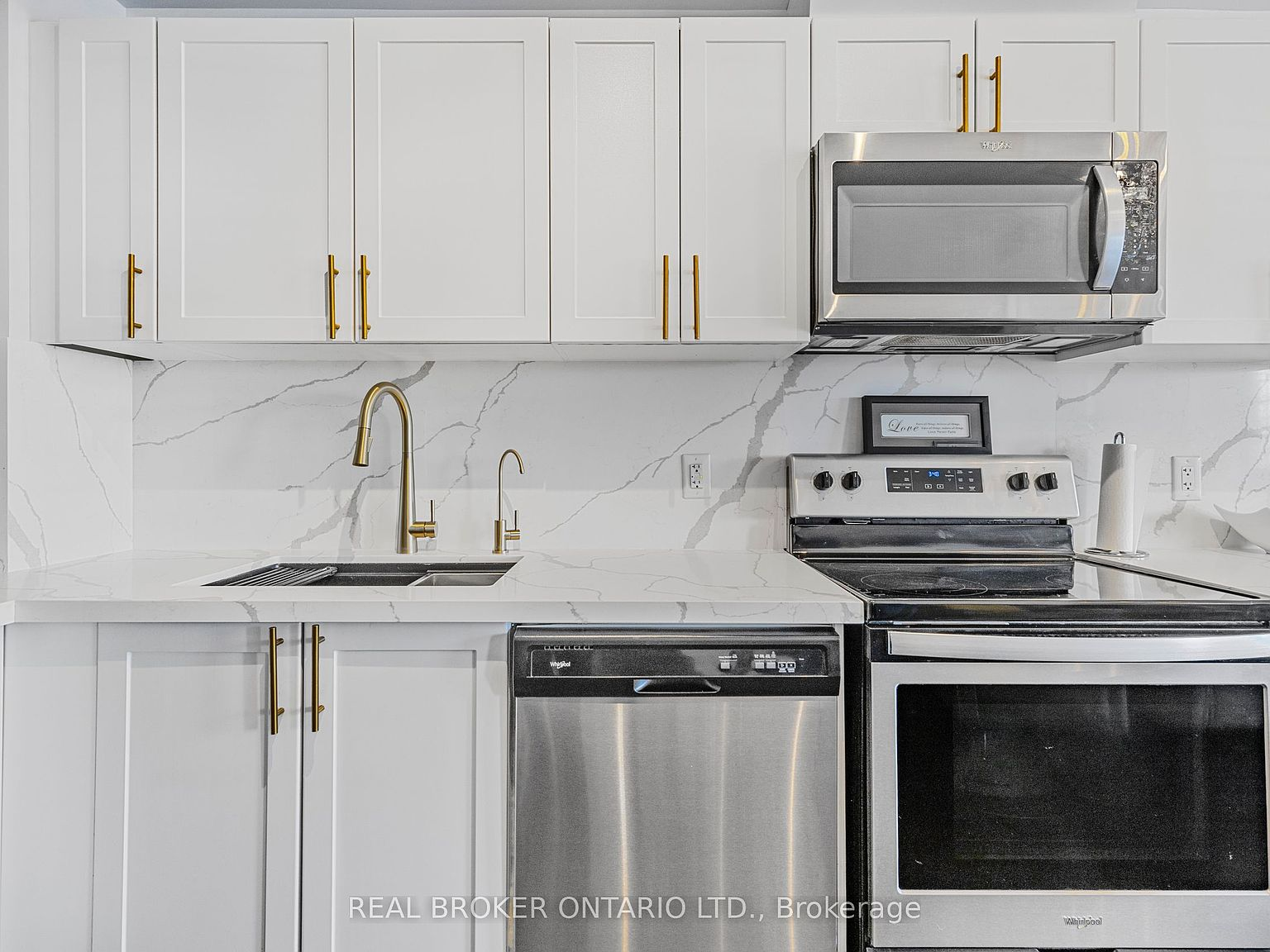 Close-up of kitchen with marble-look quartz and gold hardware