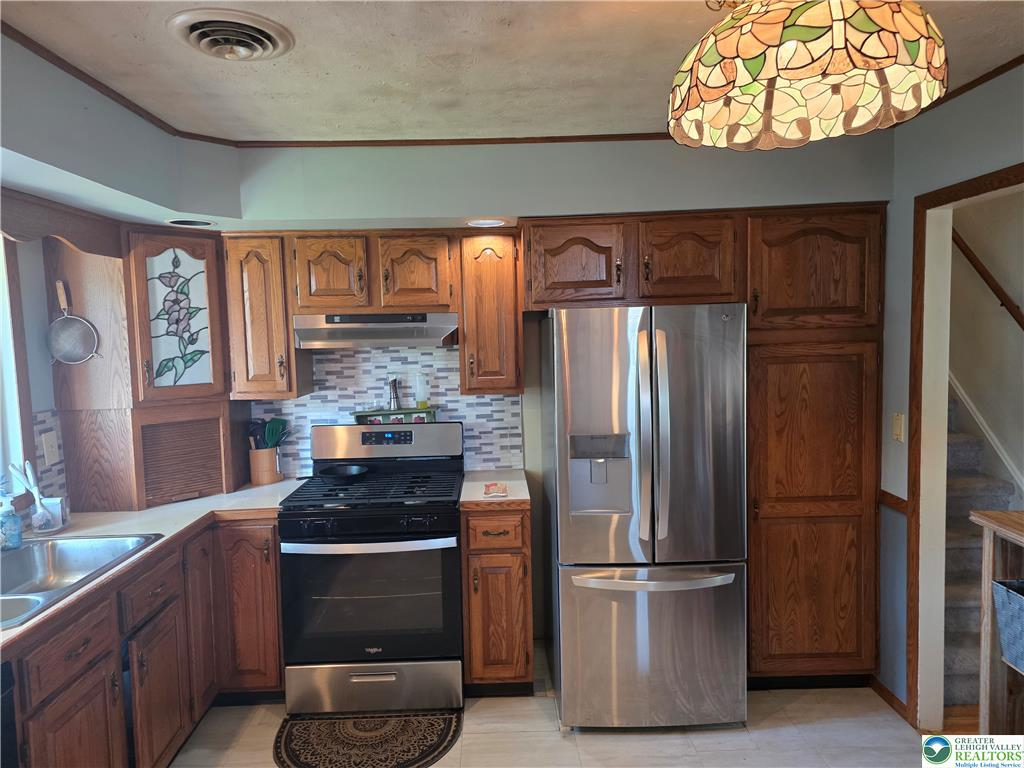 Kitchen with oak cabinets and tile backsplash