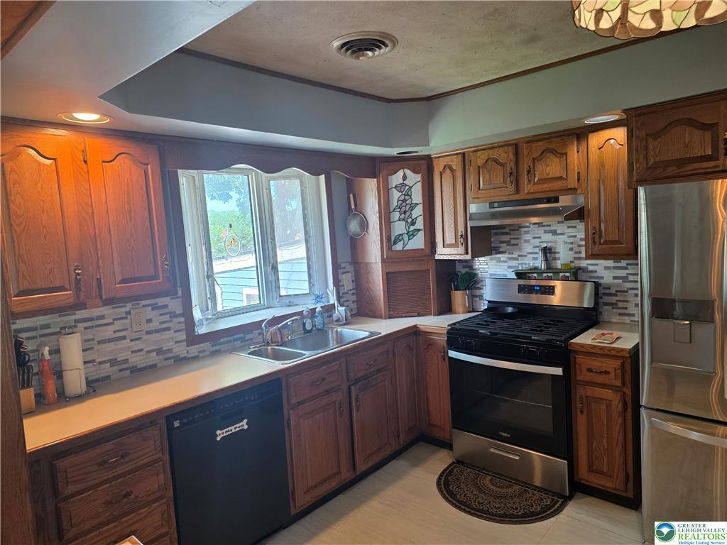 L-shaped kitchen layout with stained wood cabinets