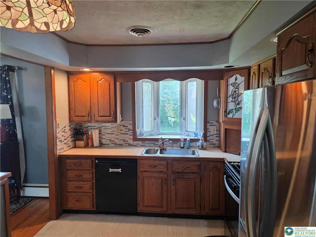 Kitchen sink area with mosaic backsplash