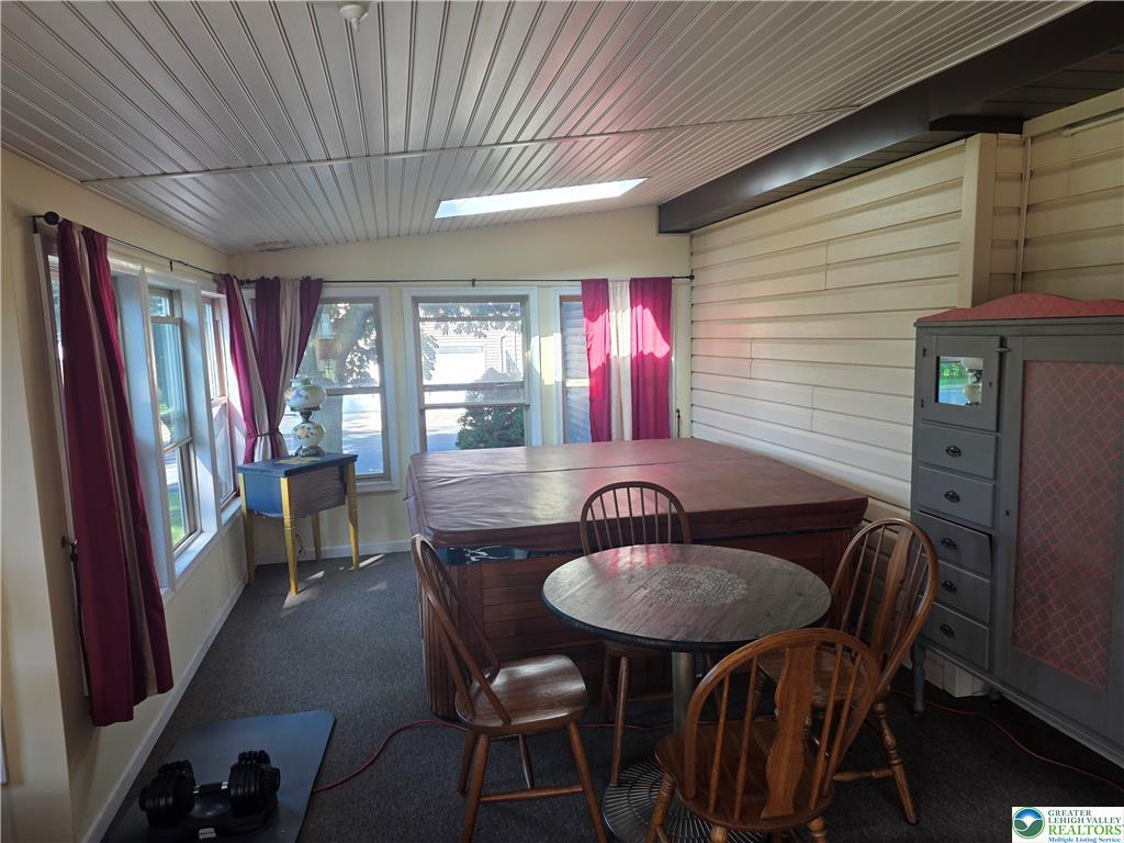Sunroom with skylight and wood ceiling