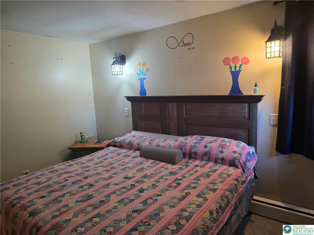 Master bedroom with headboard and carpet