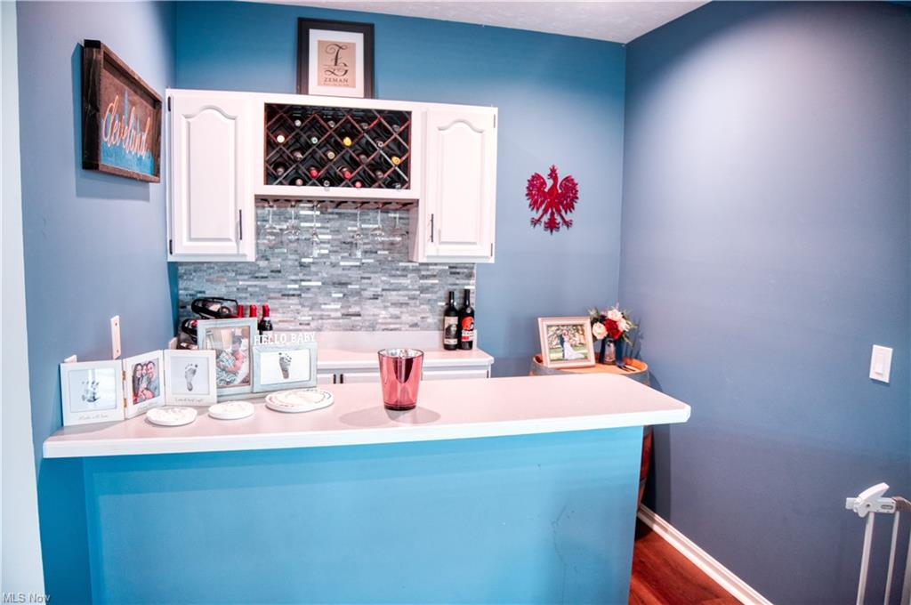 Living room with blue painted walls, white cabinets, and wooden bar counter