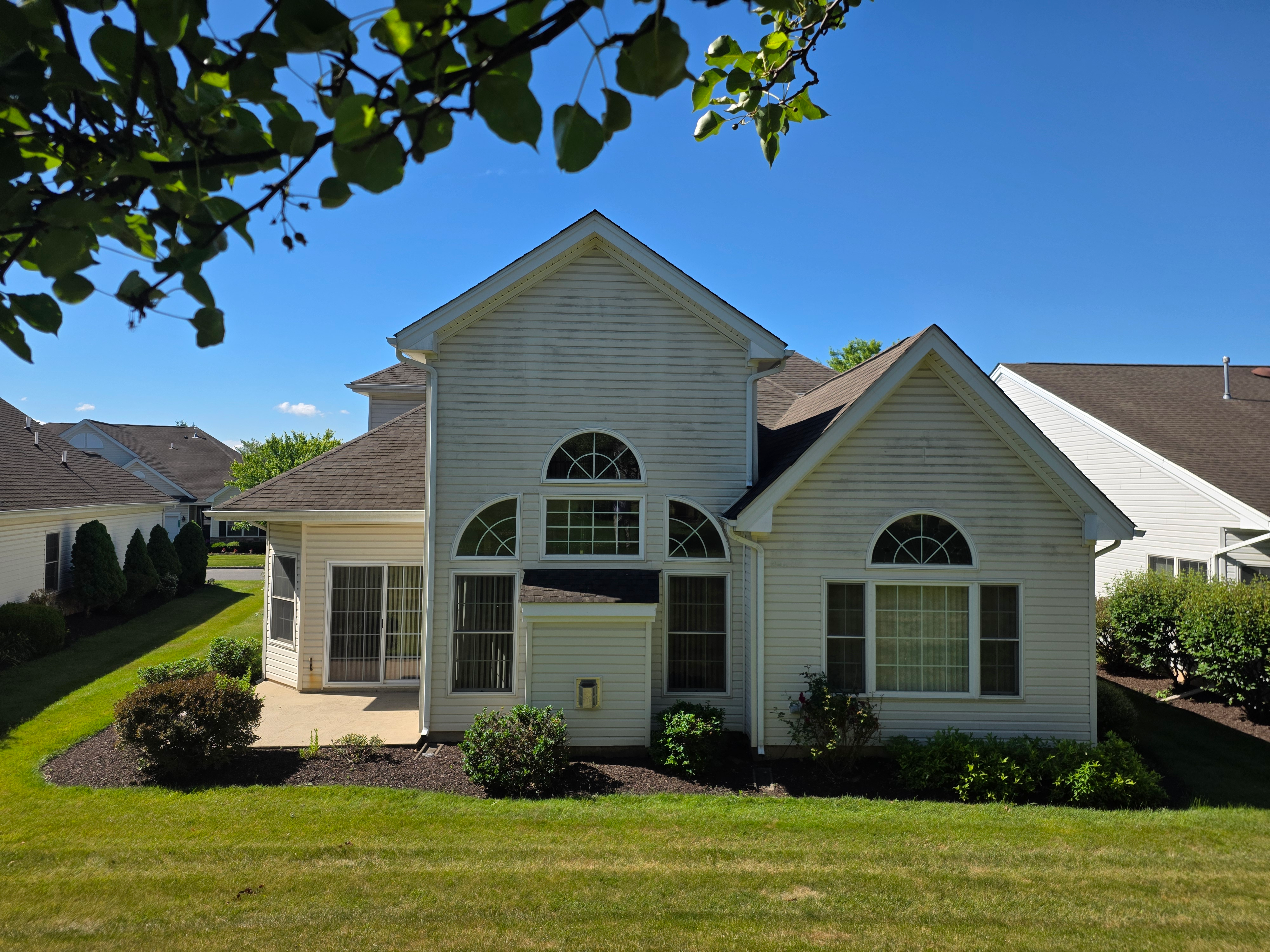 Rear facade with light vinyl siding and concrete patio