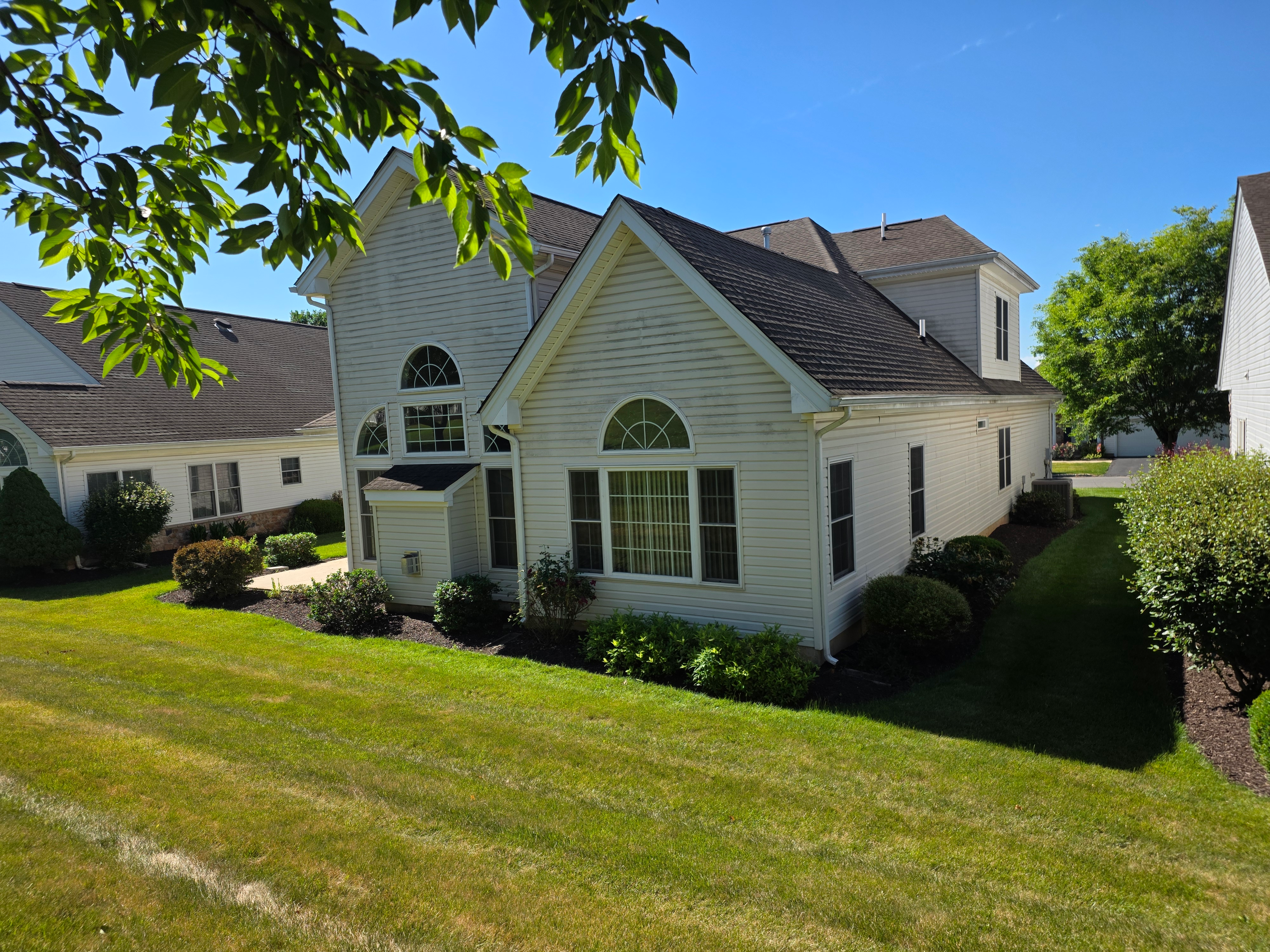 Rear view showing circle-top windows and shingle roof