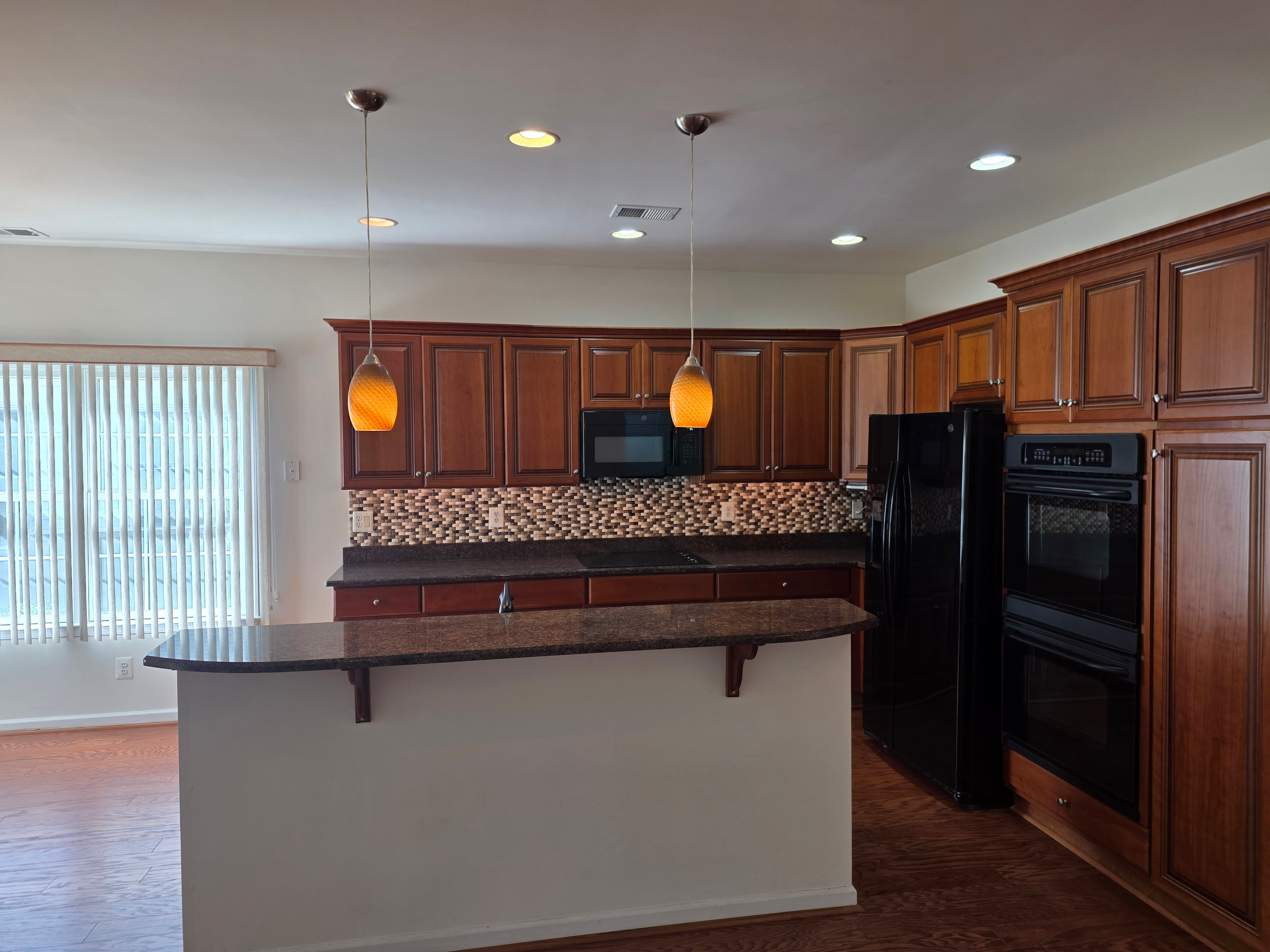 Kitchen breakfast bar with cherry wood cabinetry and granite countertops