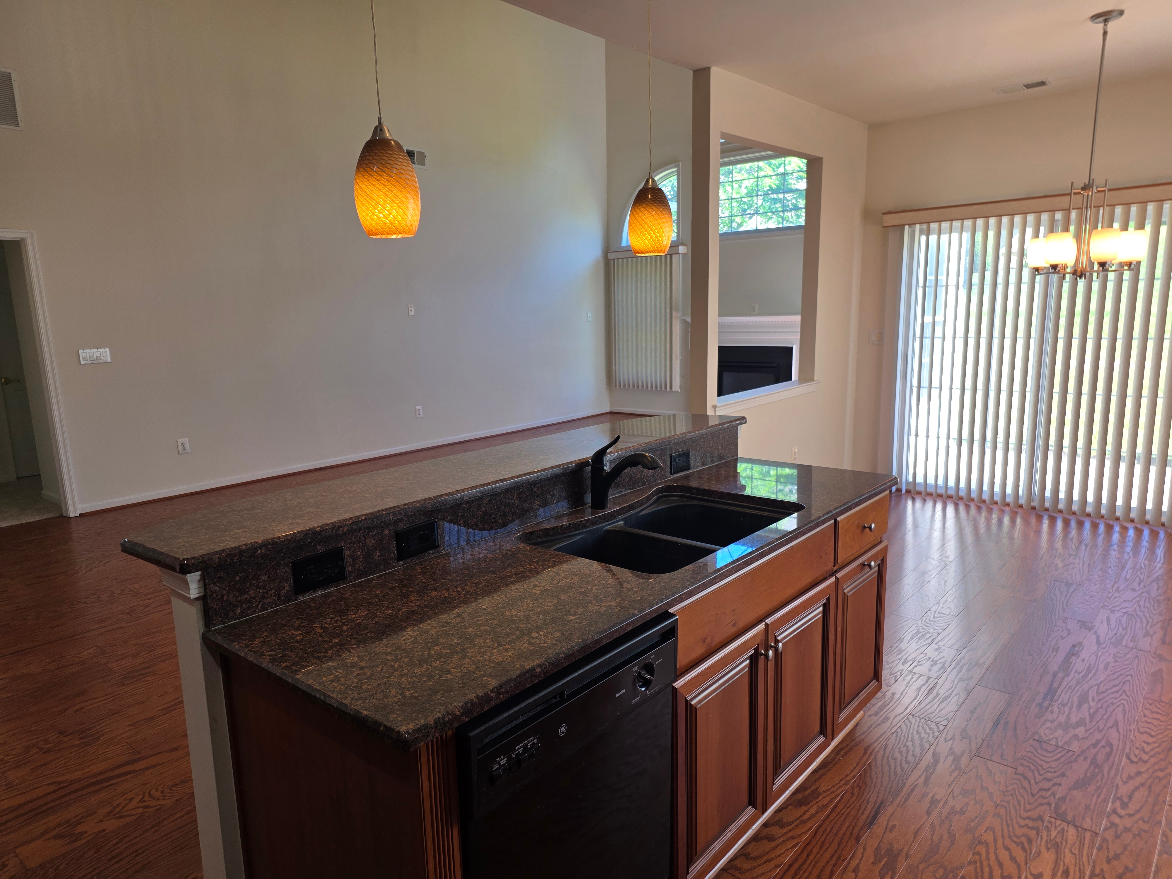 Kitchen island breakfast bar with granite counters and hardwood flooring