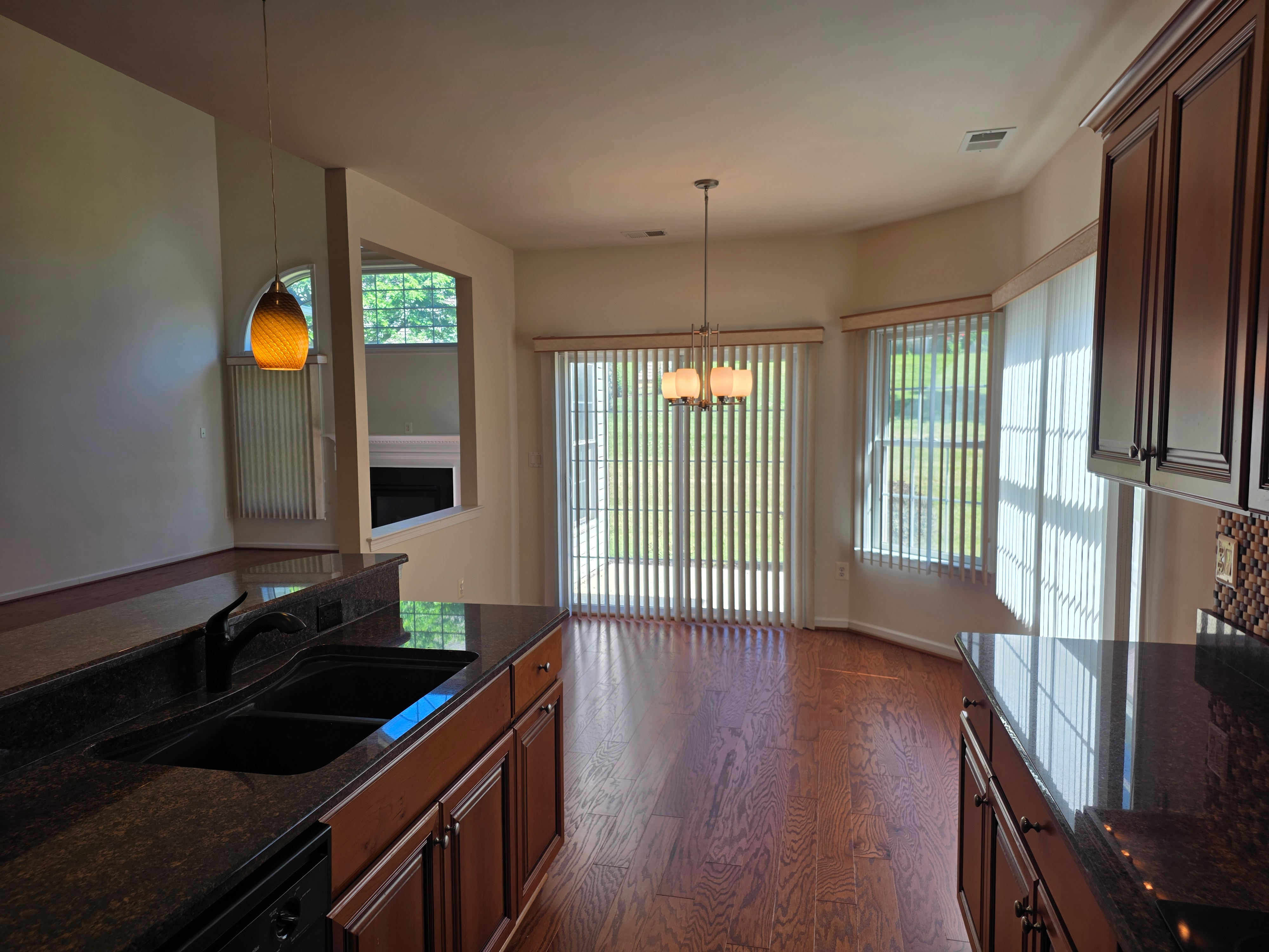 Kitchen flowing into dining area with hardwood floors