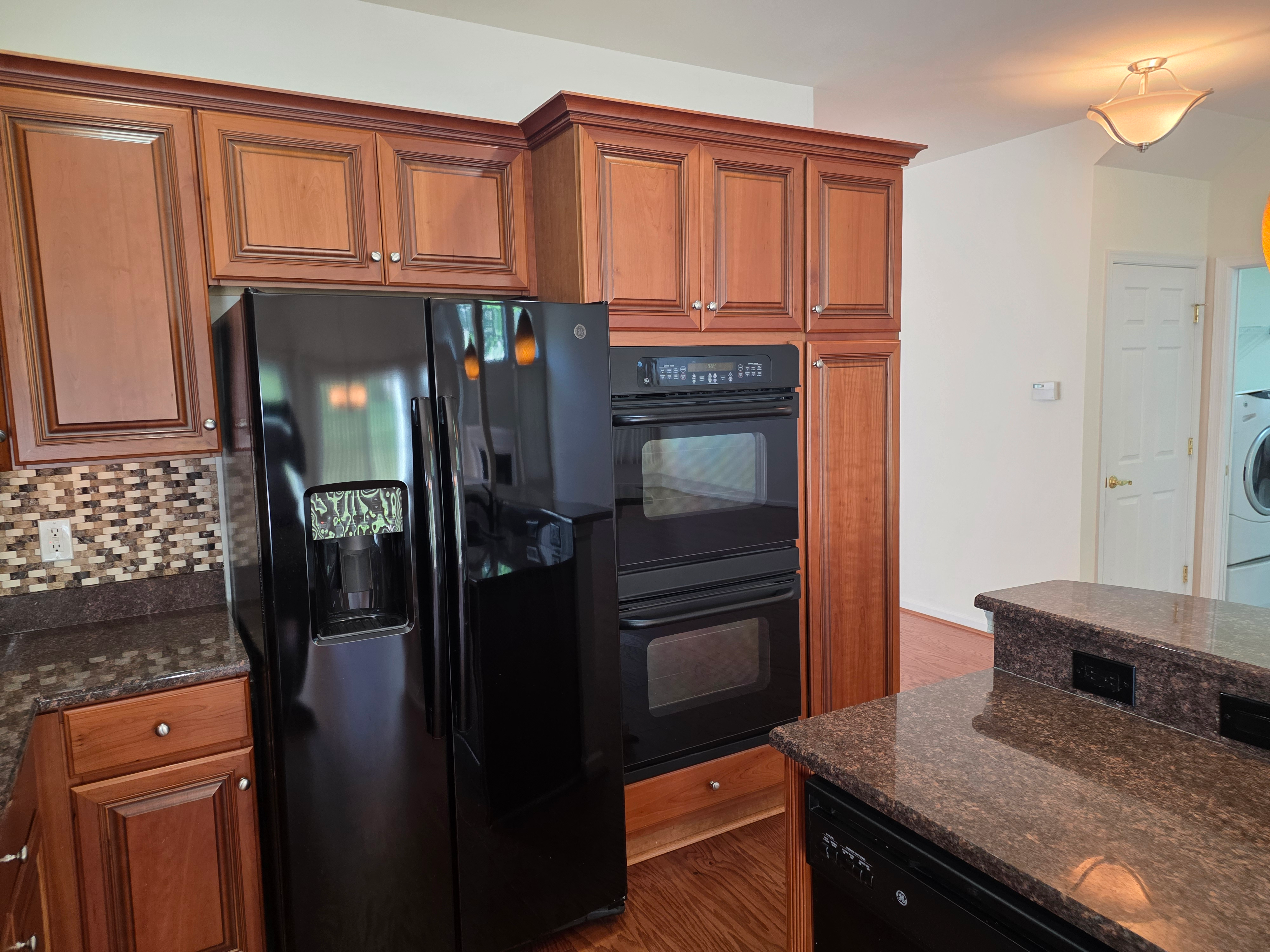Kitchen appliance wall with cherry wood cabinetry