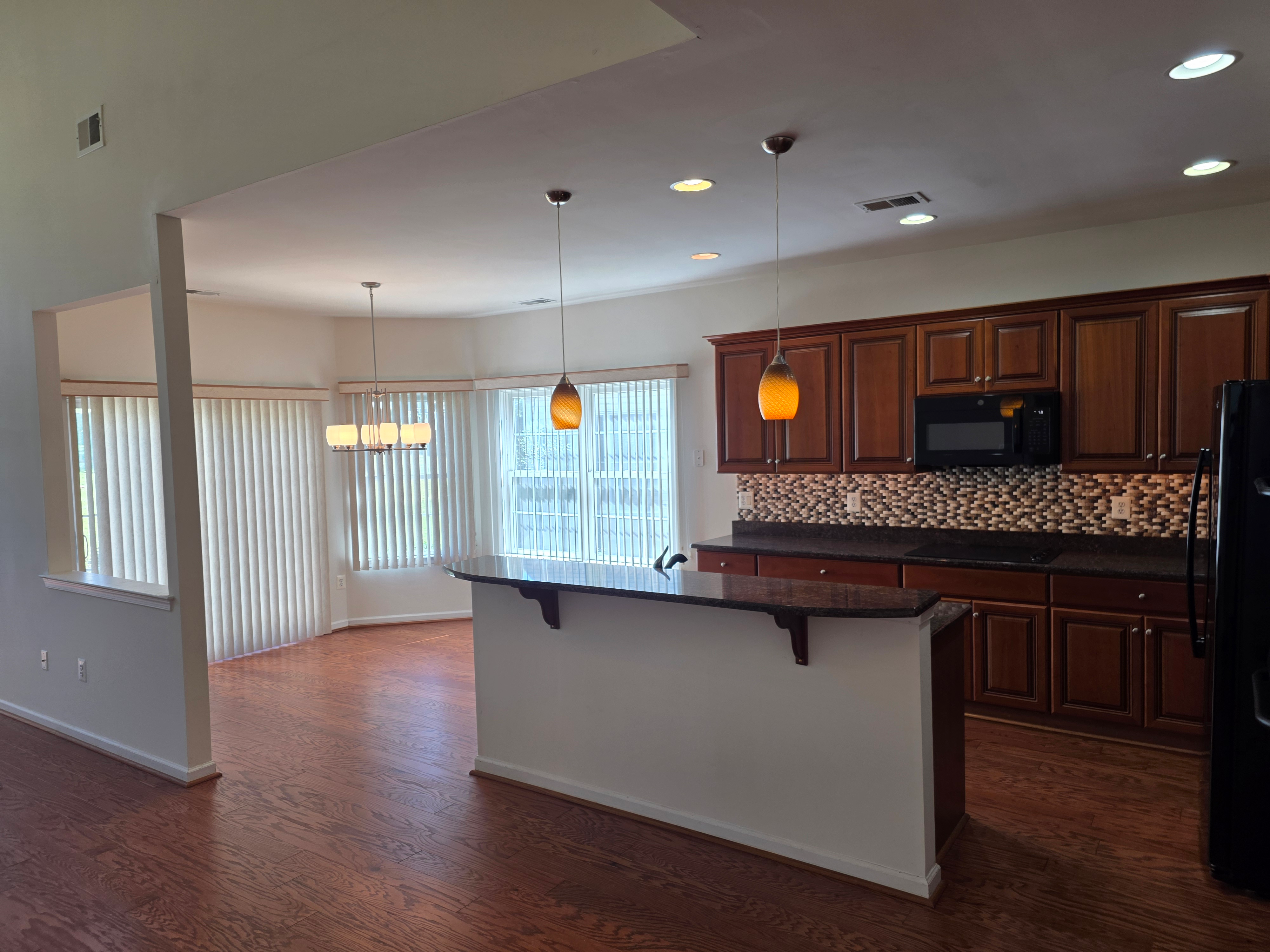 Open-concept kitchen and dining area with hardwood floors