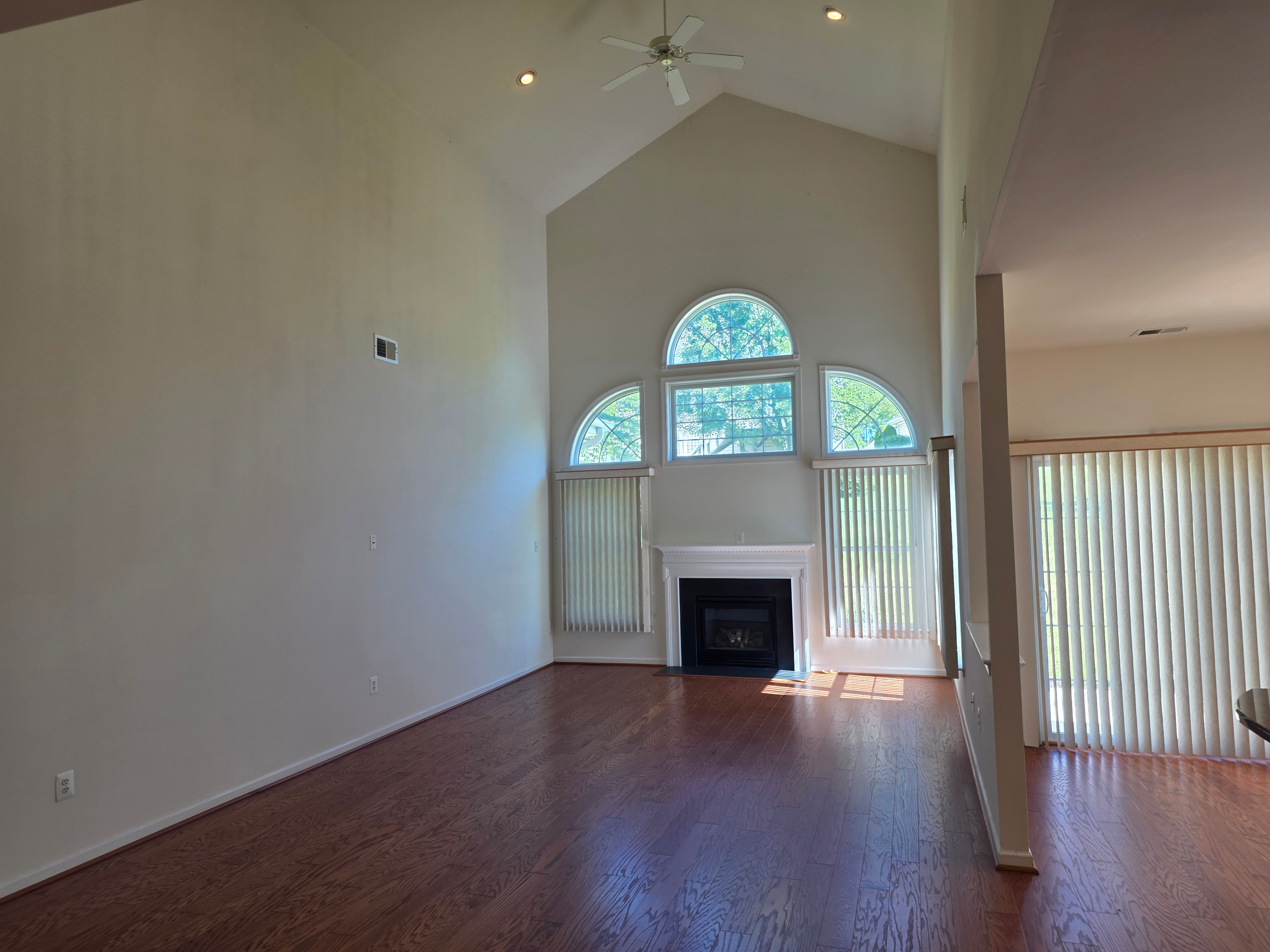Living room with vaulted ceiling, gas fireplace, and circle-top windows