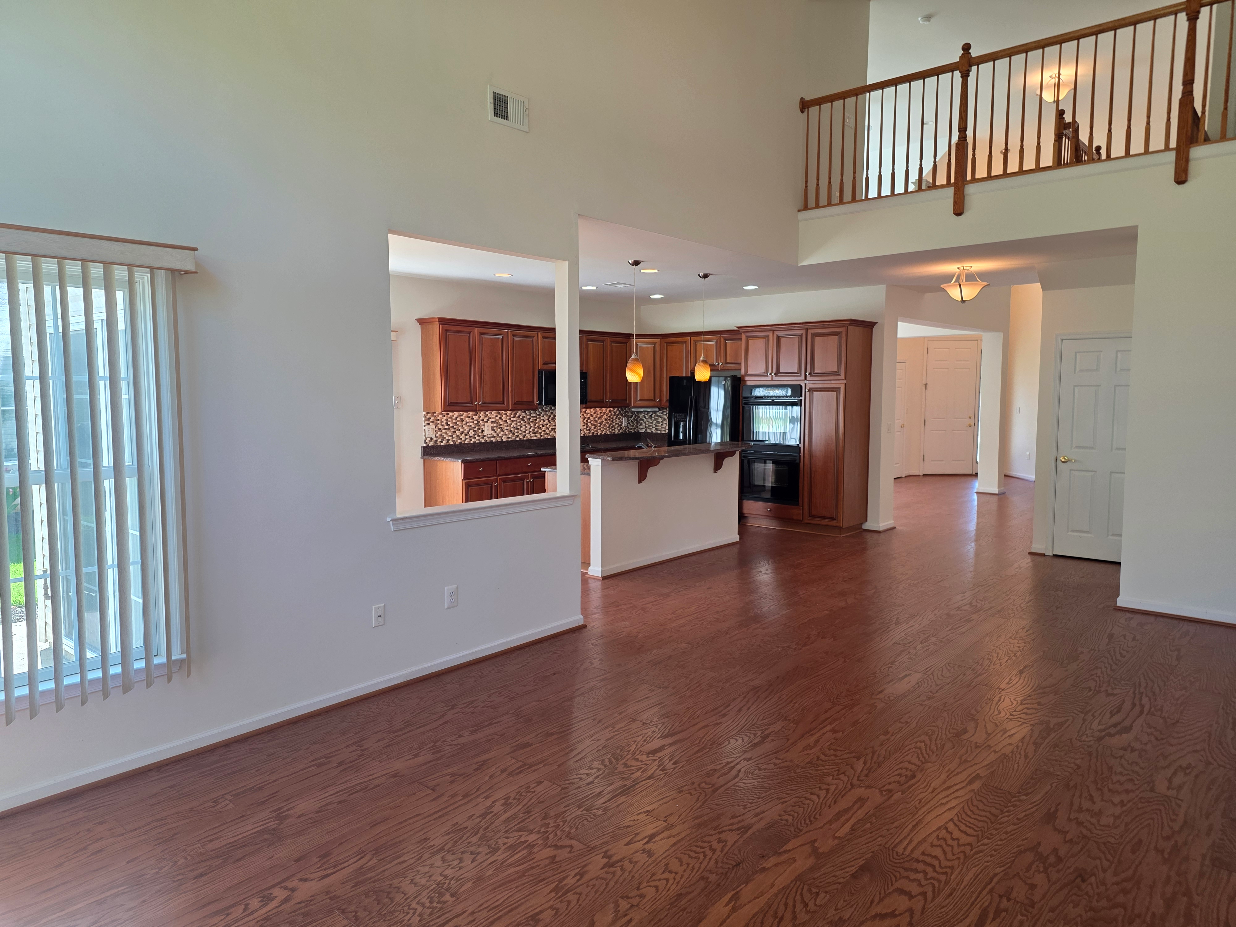 Open-concept living area looking toward kitchen and loft