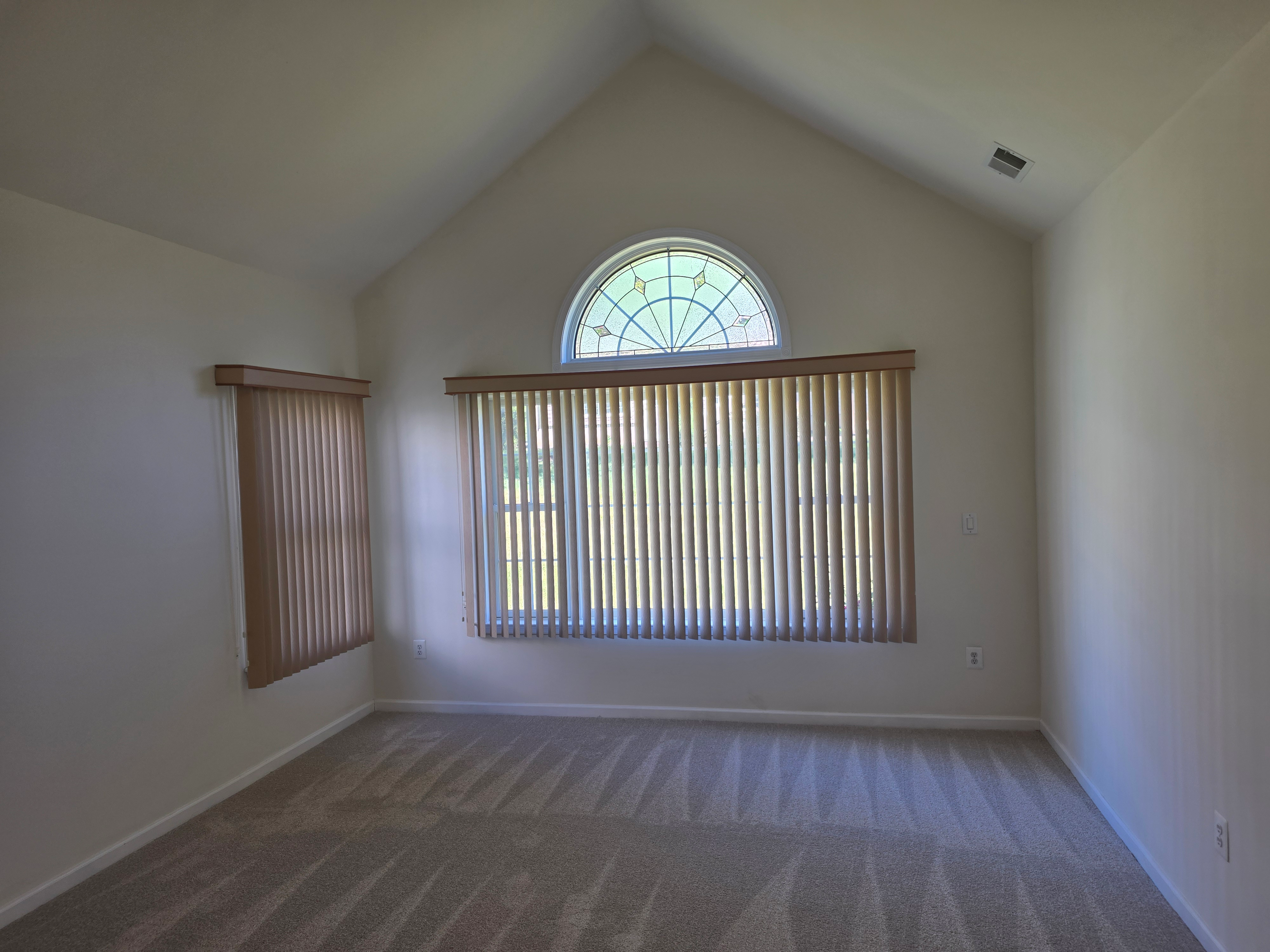 Living room with circle-top transom window and vaulted ceiling