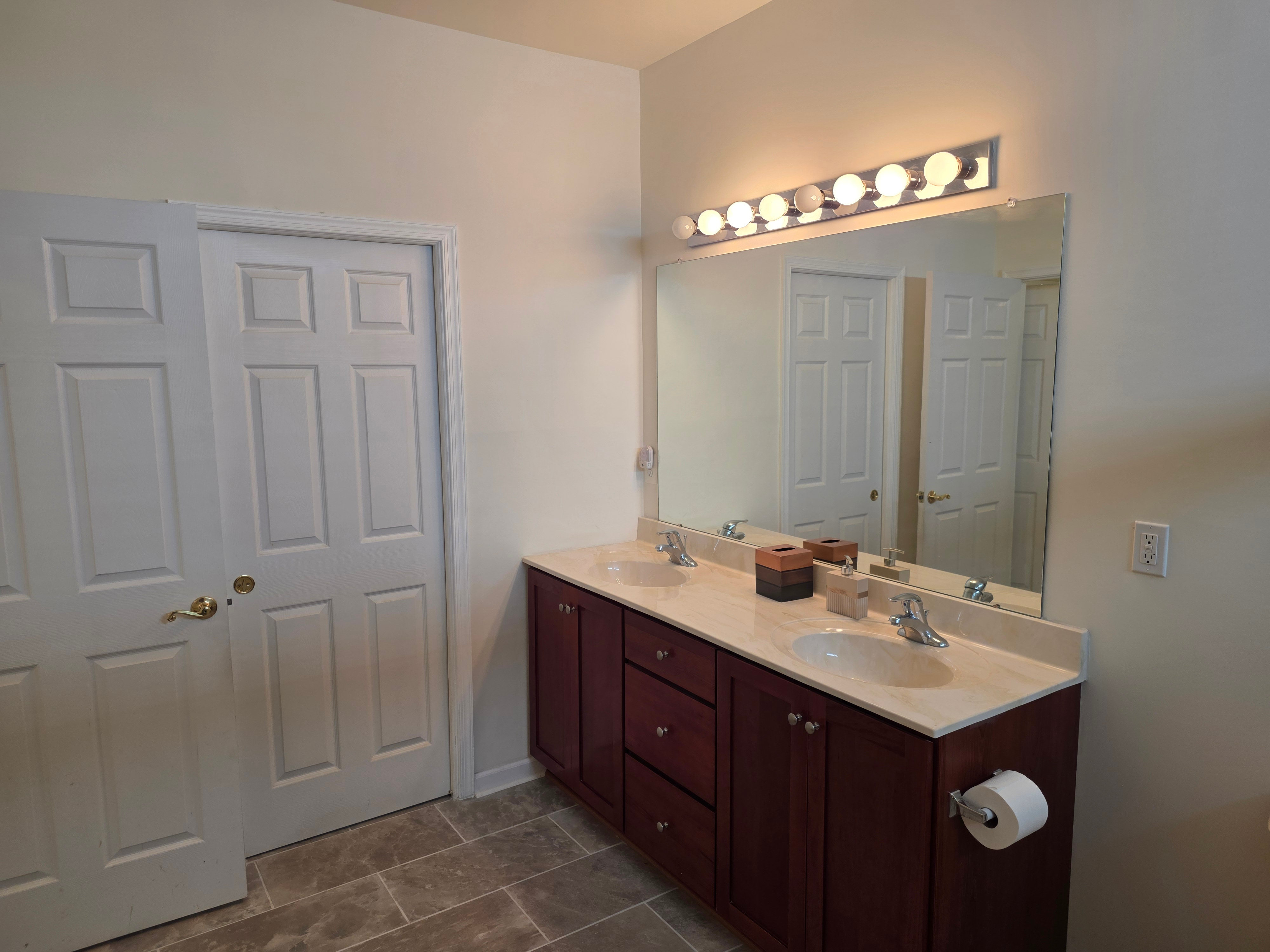Primary bathroom with double vanity and large mirror