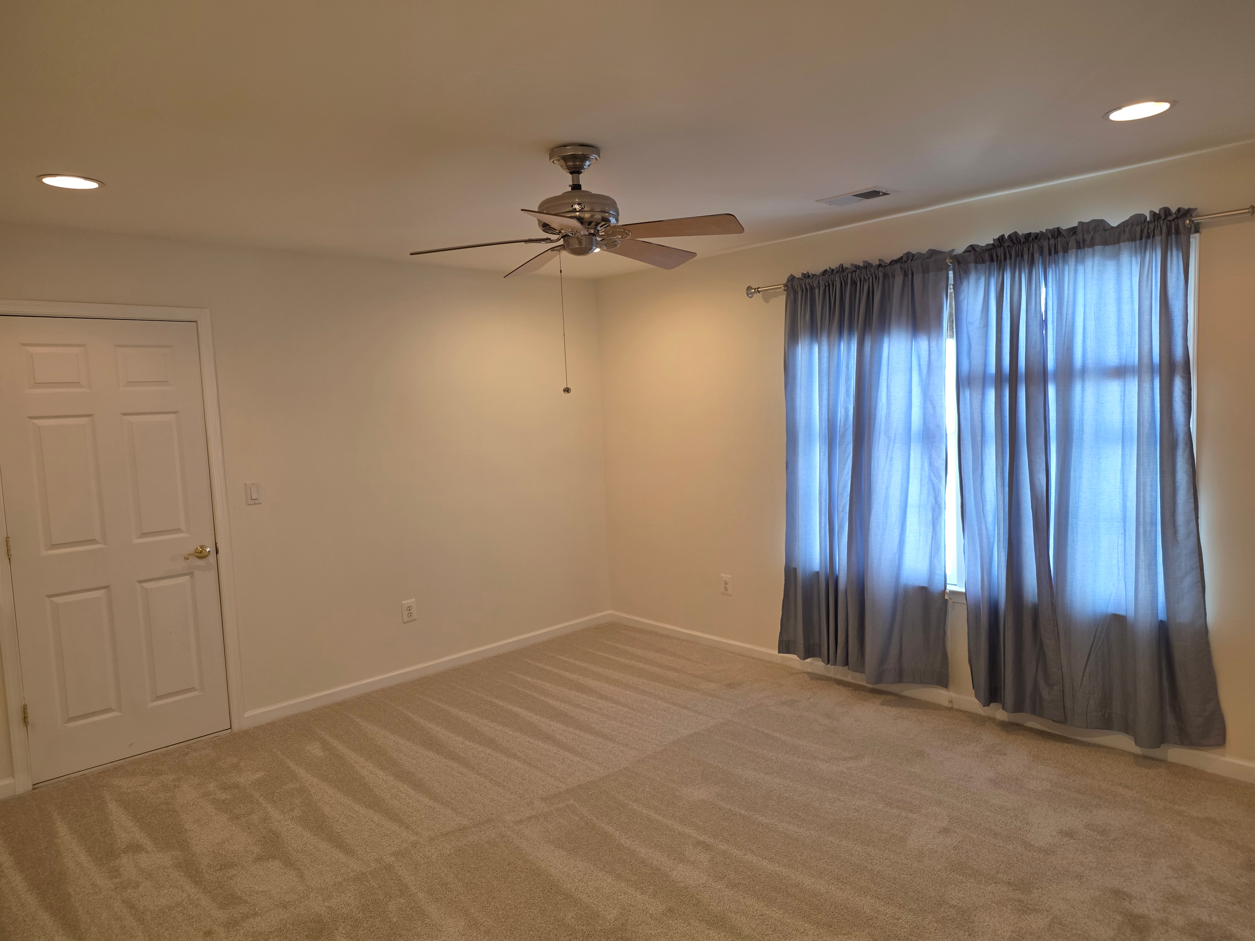 Bedroom interior with vaulted ceiling and window