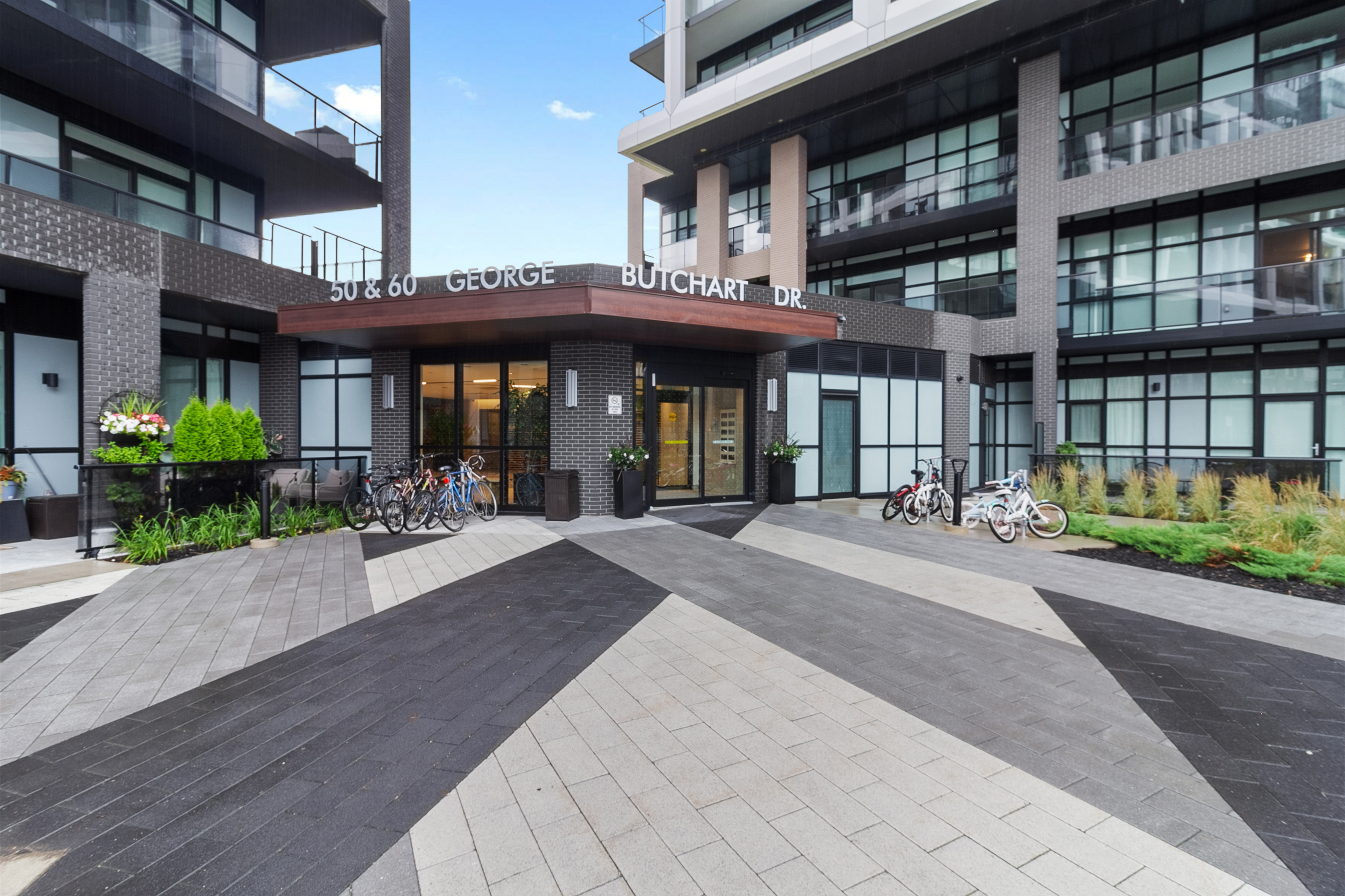 Condo building entrance with dark brick cladding and glass storefronts