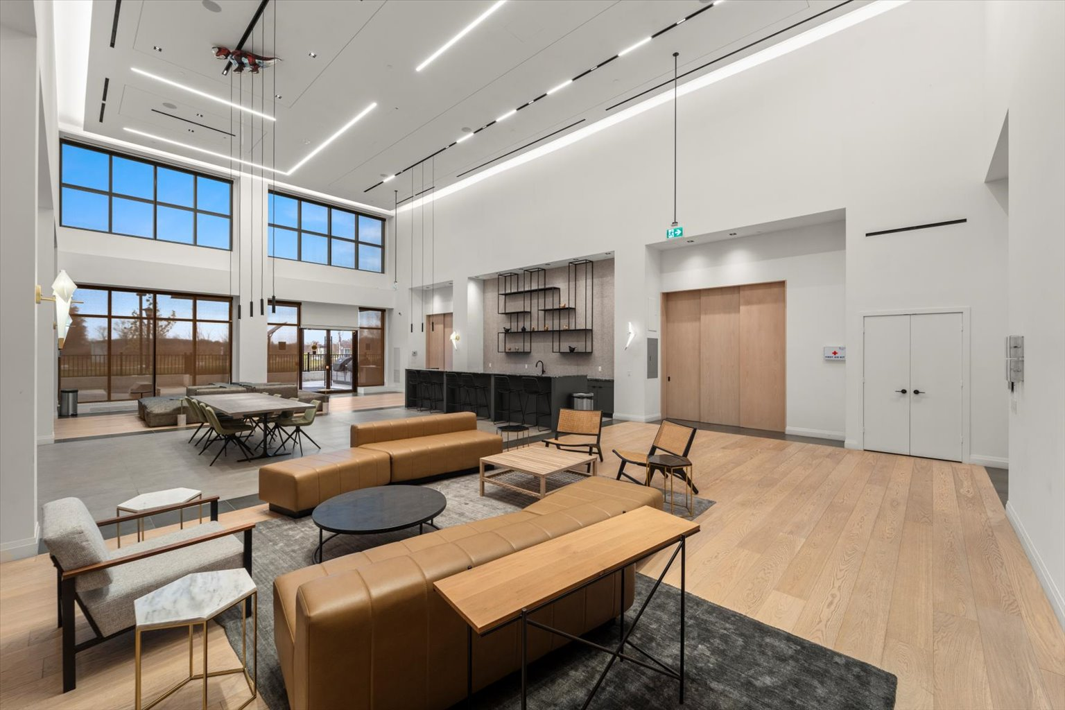 High-ceiling social lounge with industrial-style windows