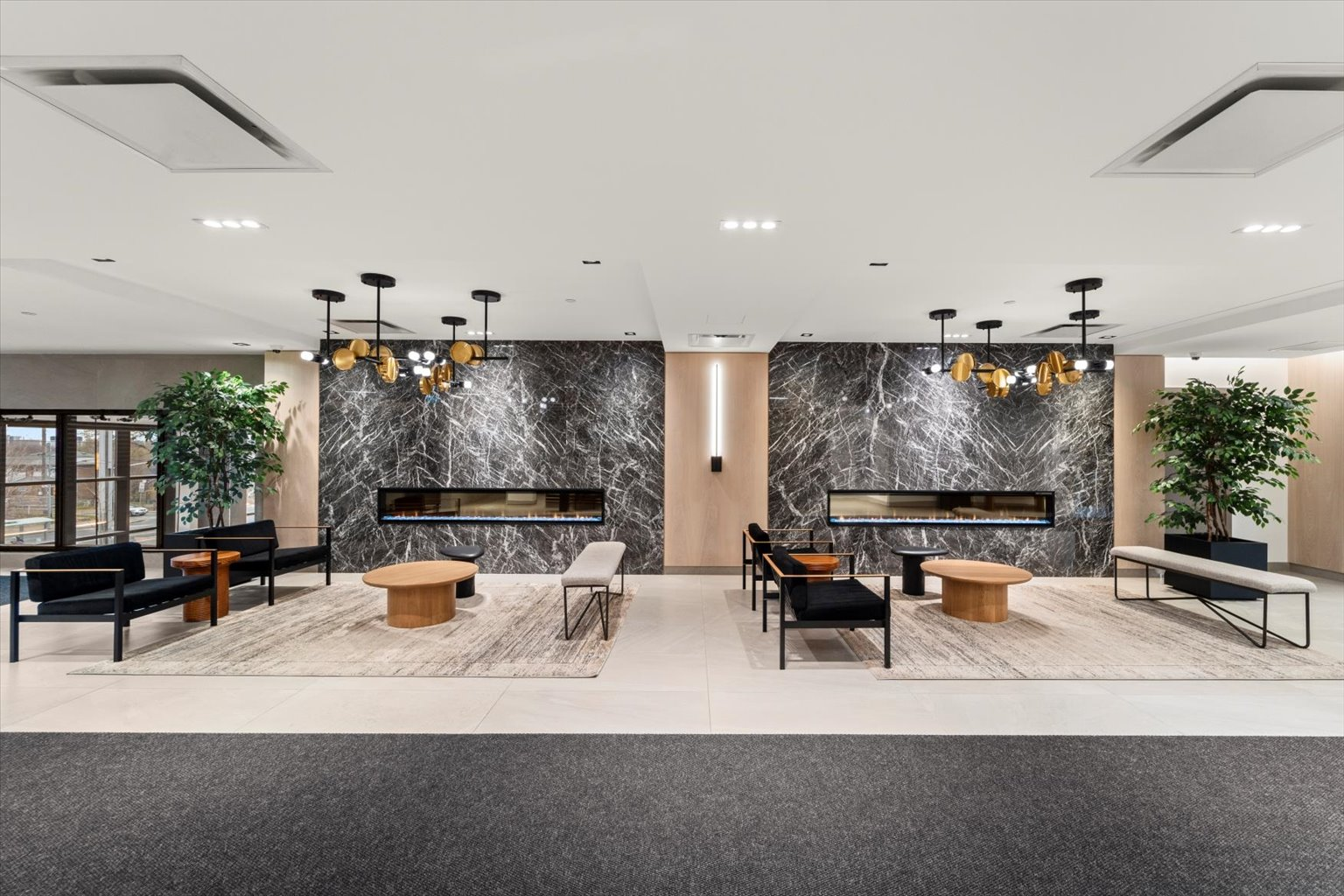Lobby lounge with dark marble fireplace walls and chandeliers