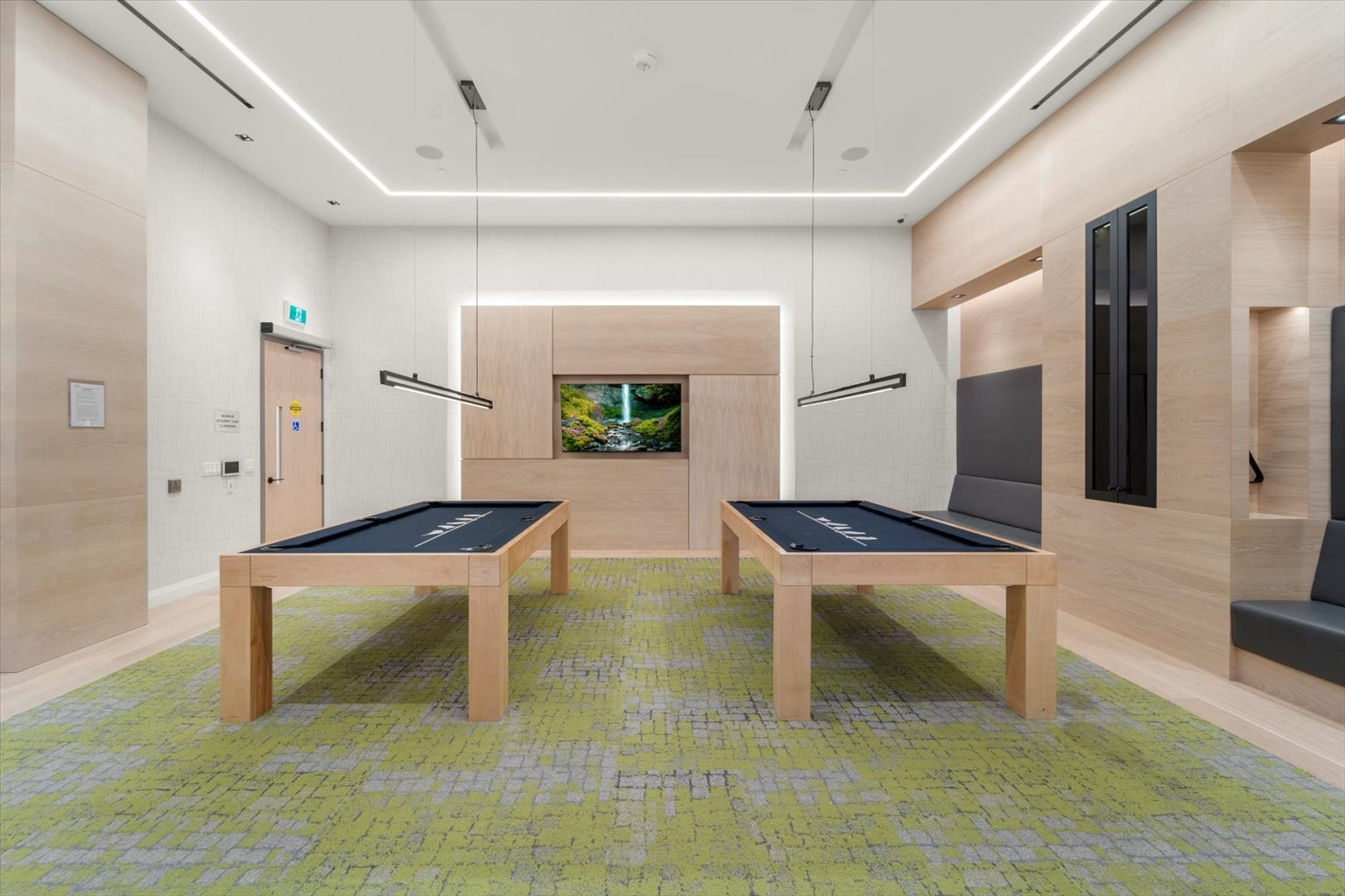 Game room with billiard tables and linear light fixtures