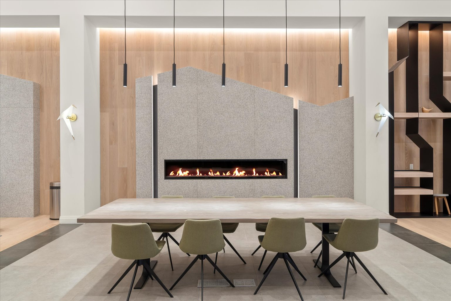 Communal room with gas fireplace, dining table, and pendant lights