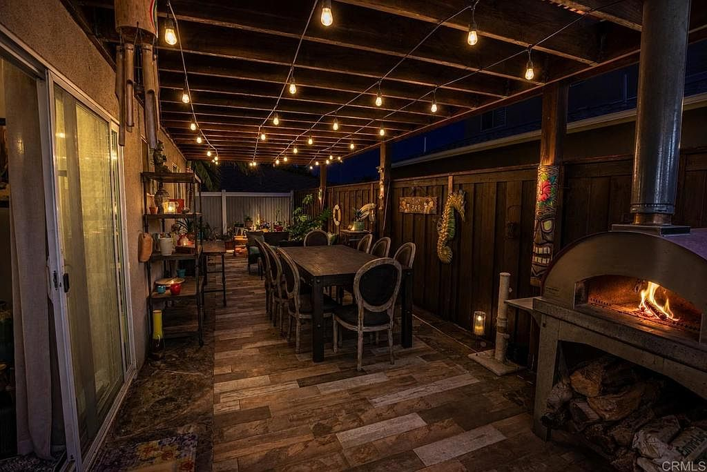 Backyard covered patio with pergola, string lighting, and porcelain wood-plank tile flooring