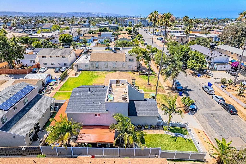 Aerial view showing the backyard resort layout, pergolas, and rooftop deck