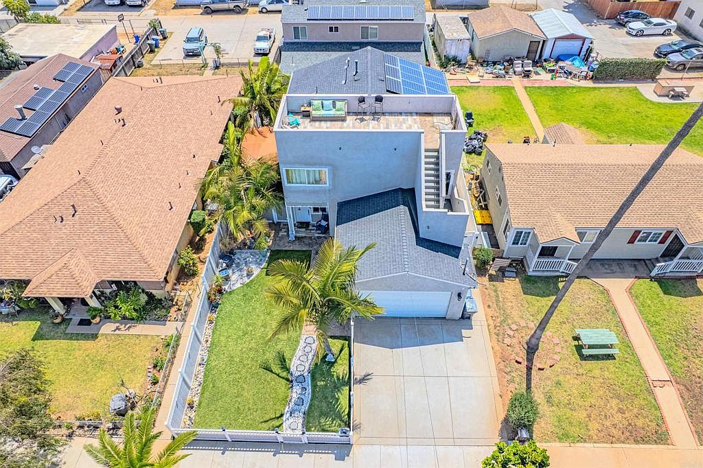 Aerial drone shot of 569 Delaware St showing rooftop deck, solar panels, and landscaped yard