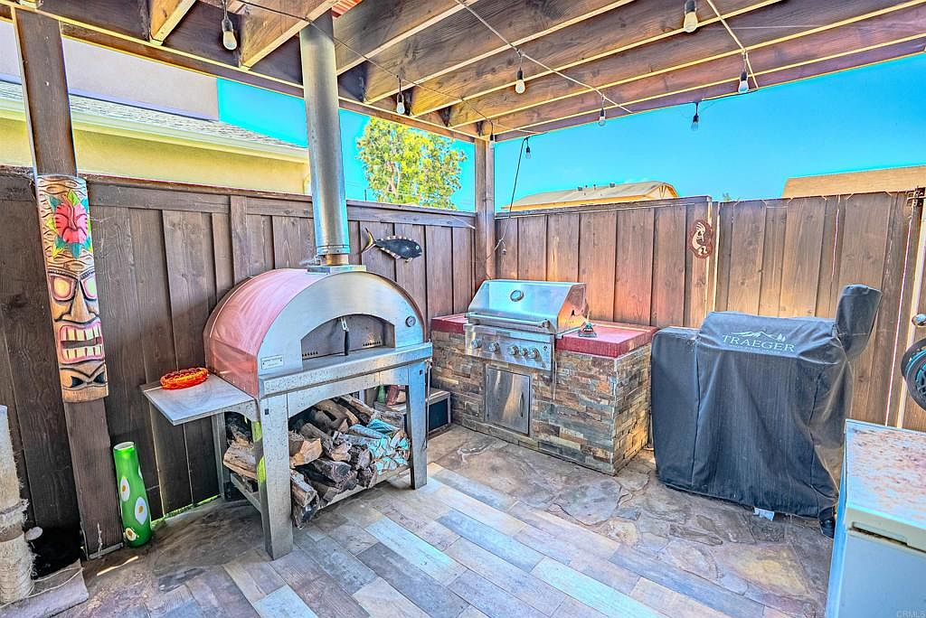 Outdoor kitchen with built-in BBQ and Italian wood-fired pizza oven